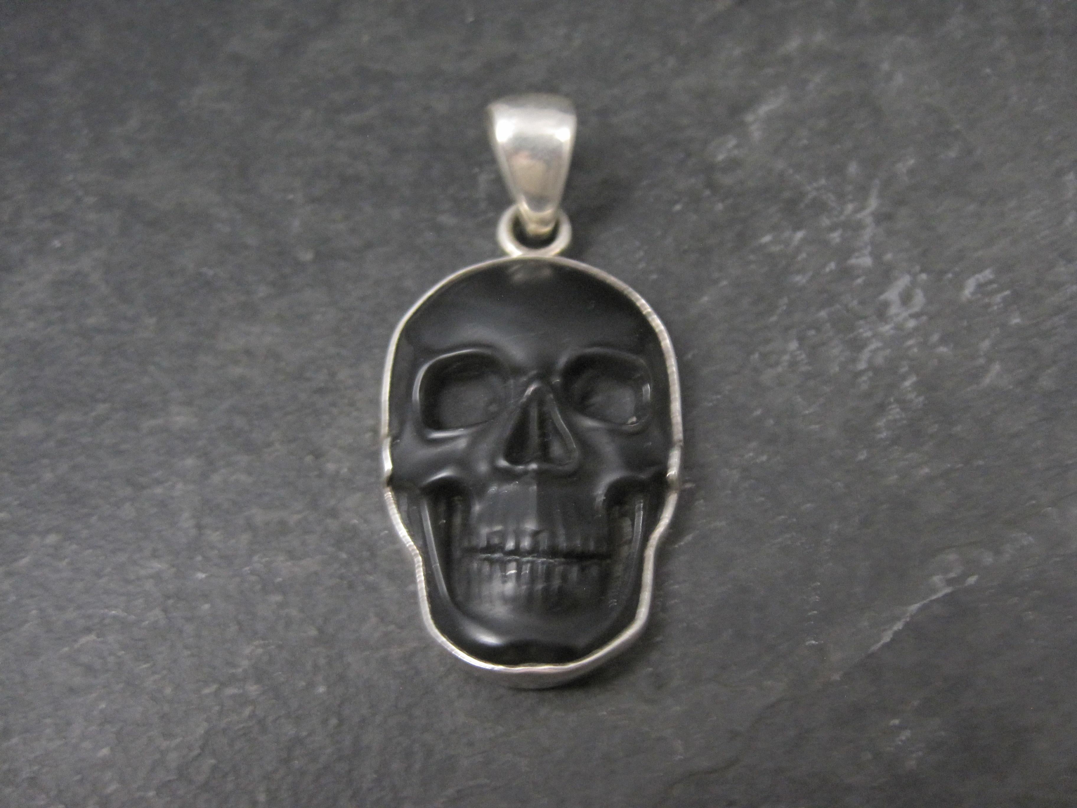 This gorgeous, sterling silver, hand-carved obsidian skull pendant is a creation of Charles Albert.

Measurements: 1 1/16 by 2 1/4 inches including bail
Bail will accommodate a chain up to 5mm wide

Condition: Excellent
