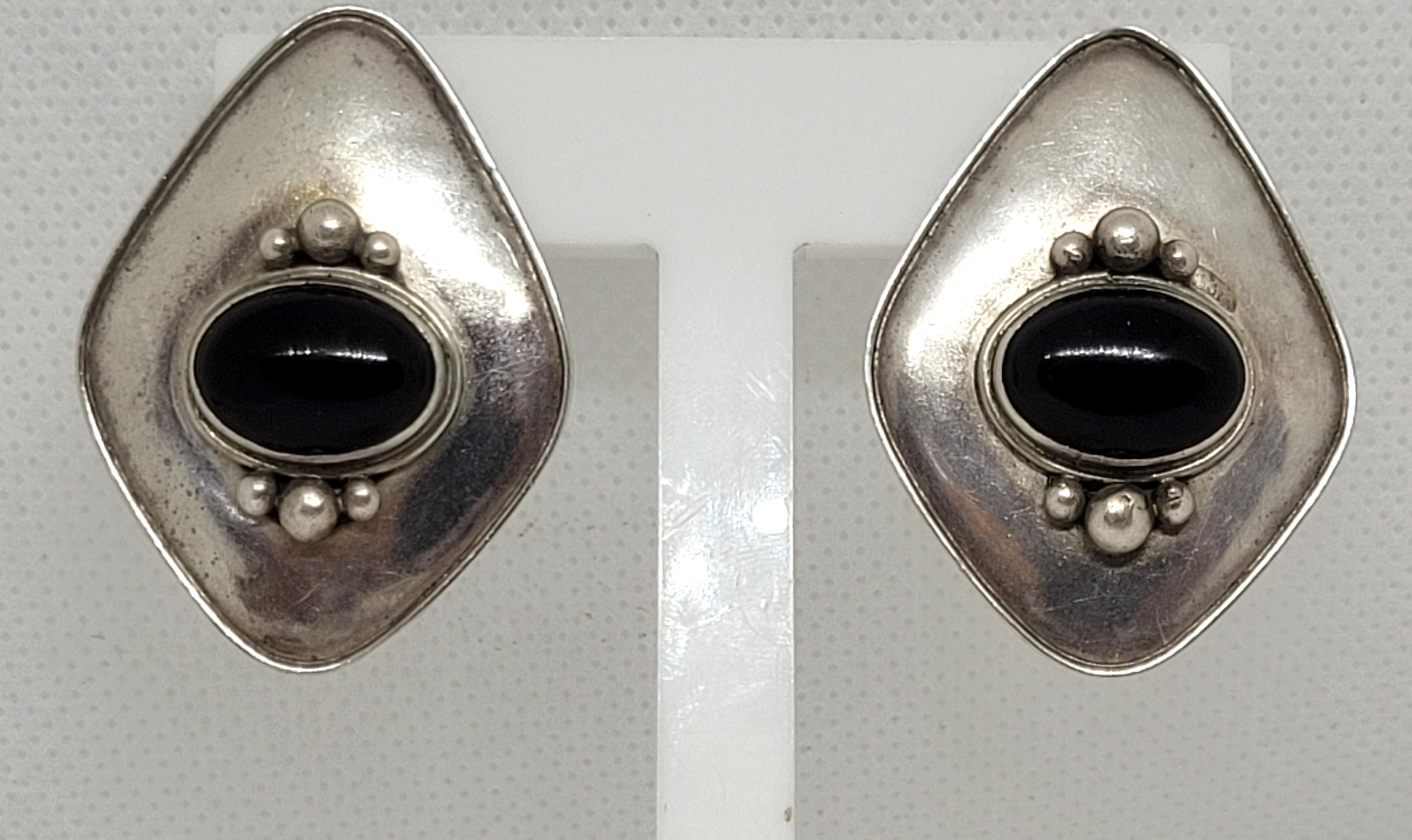 Sterling silver onyx friction post earrings. These earrings are stamped by the designer and marked as sterling silver. They are 39mm x 28mm in size, weigh 10.5 grams, and have bezel-set black onyx, and a beaded design.
Lovely design and quality with