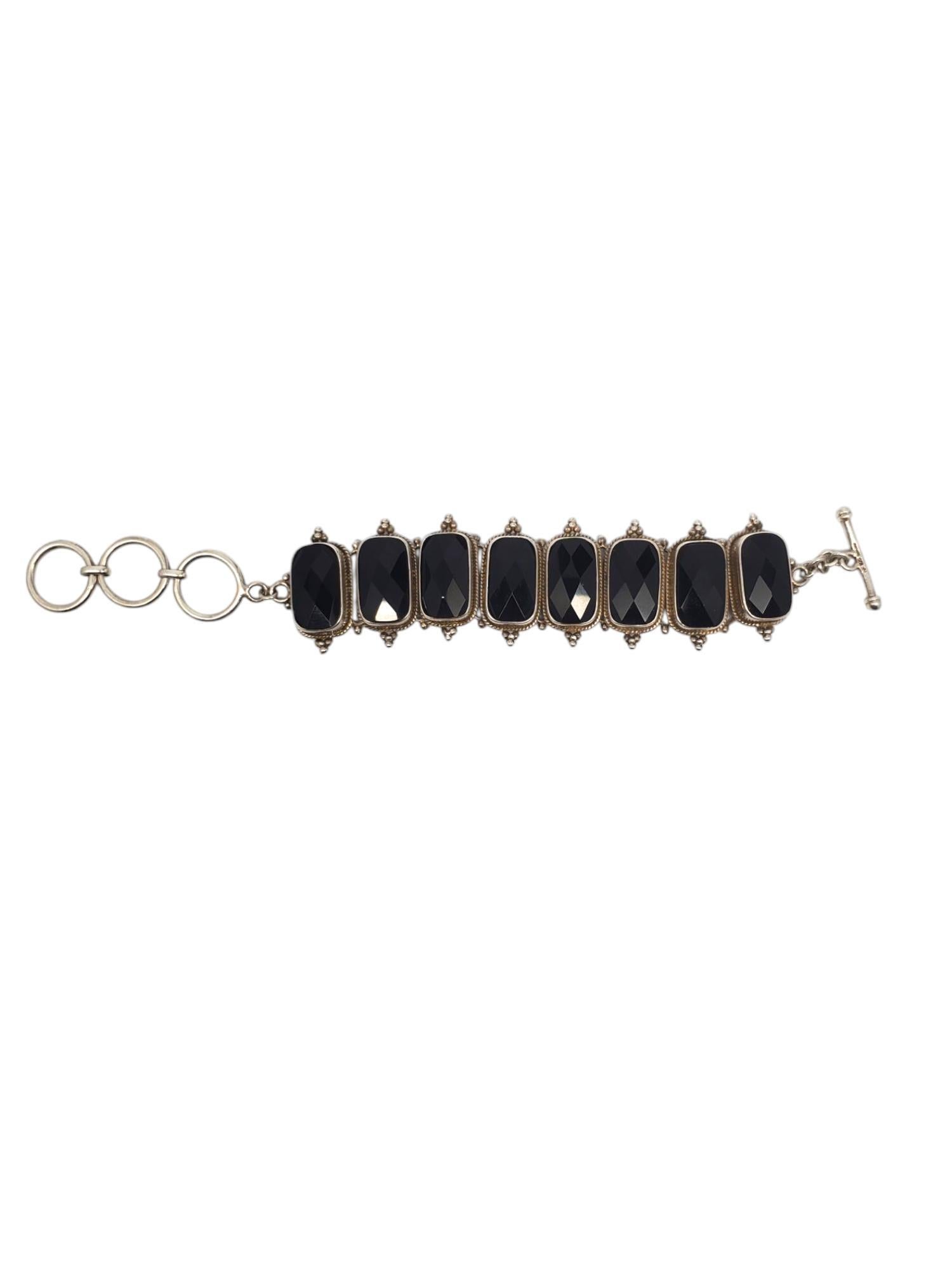 Bracciale con maglie in argento nero e onice - A. Silver

Questo bracciale vintage a maglie presenta 8 pietre rettangolari di onice nero sfaccettate (18 mm x 10,8 mm) in un involucro decorativo in argento sterling con chiusura ad alamari
