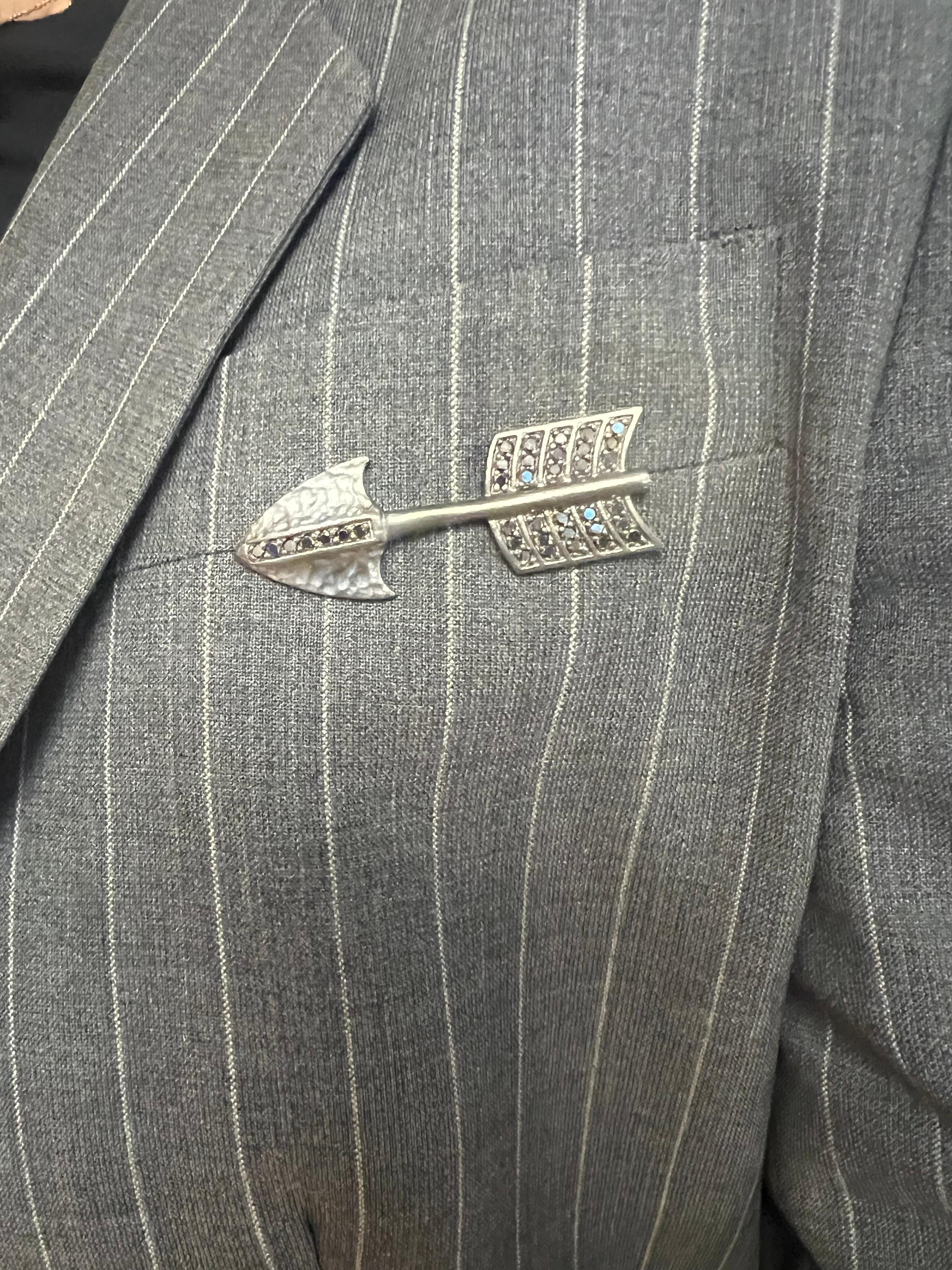 Introducing the epitome of sophistication and bold elegance: the Black Rhodium Sterling Silver Arrow Pin, a timeless accessory that merges strength with refinement. Crafted with meticulous attention to detail, this exquisite pin features a sleek