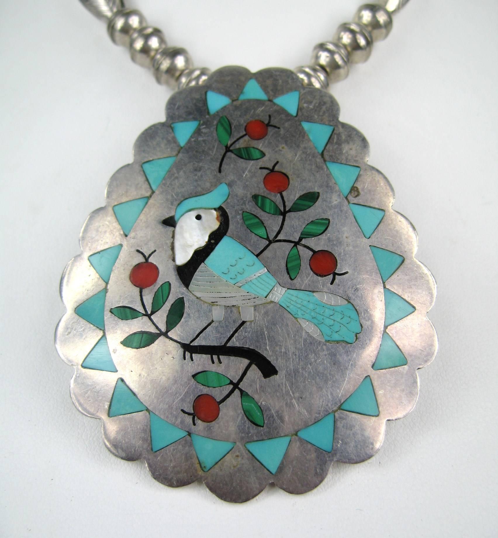 Sammy and Esther Guardian Blue Jay Motif Pendant set in Sterling Silver. Inlaid with Turquoise and coral.  The Pendant attached to a beaded necklace Hallmarked on the back. Measures 2.60in  x 2.10 in and the necklace is 22 inches end to end. This is