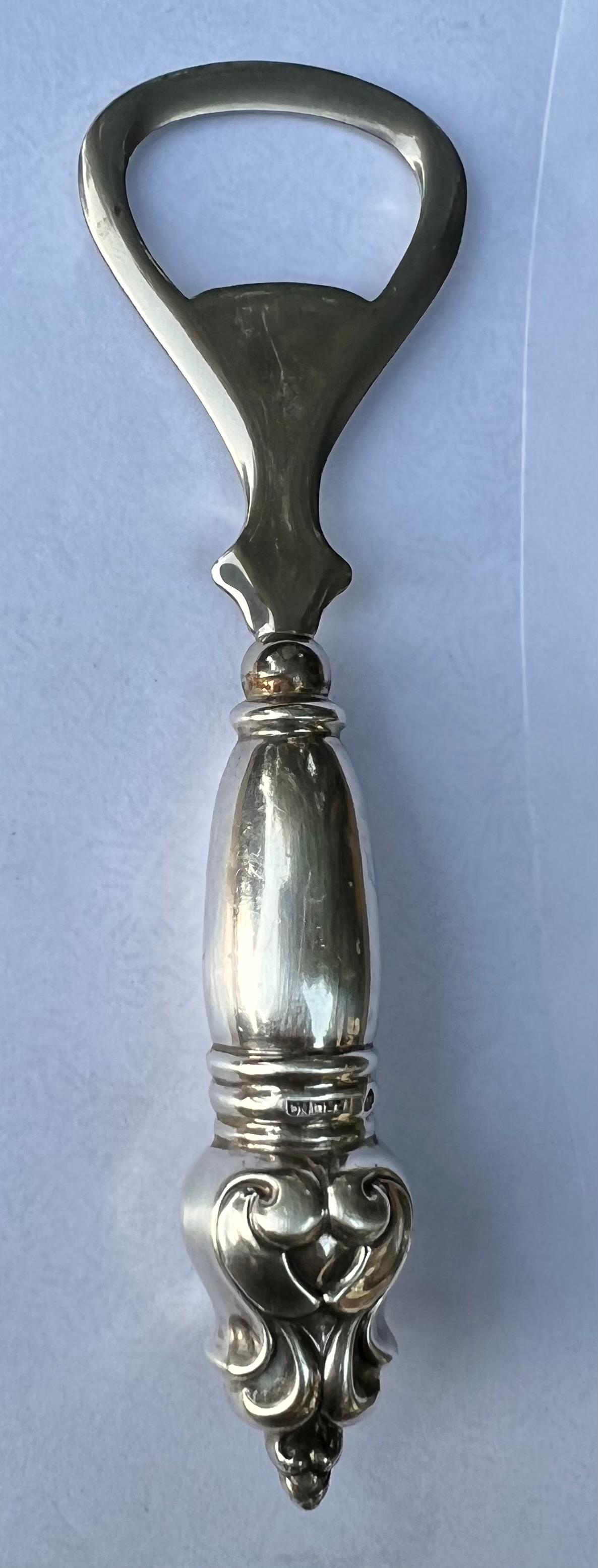 Simpson Hall Miller Sterling Silver Stainless Bottle Opener with Weighted Handle. Marked NX6. Bring sophistication to any bar and open bottles with style and ease. Makes a lovely gift. 

Simpson Hall Miller was taken over by International Silver