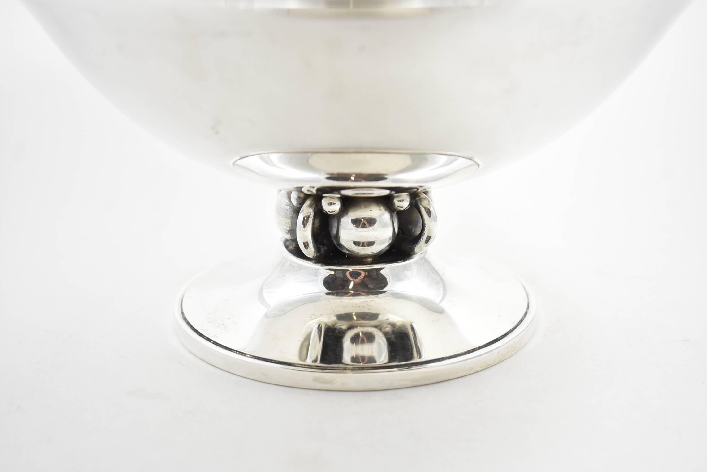An impressive sterling silver bowl by Alphonse Lapaglia for International Sterling. Alphonse Lapaglia is known for his distinct designs and studied under Georg Jensen. This bowl has loop and ball detail on a footed bottom. It is numbered 139 14 on