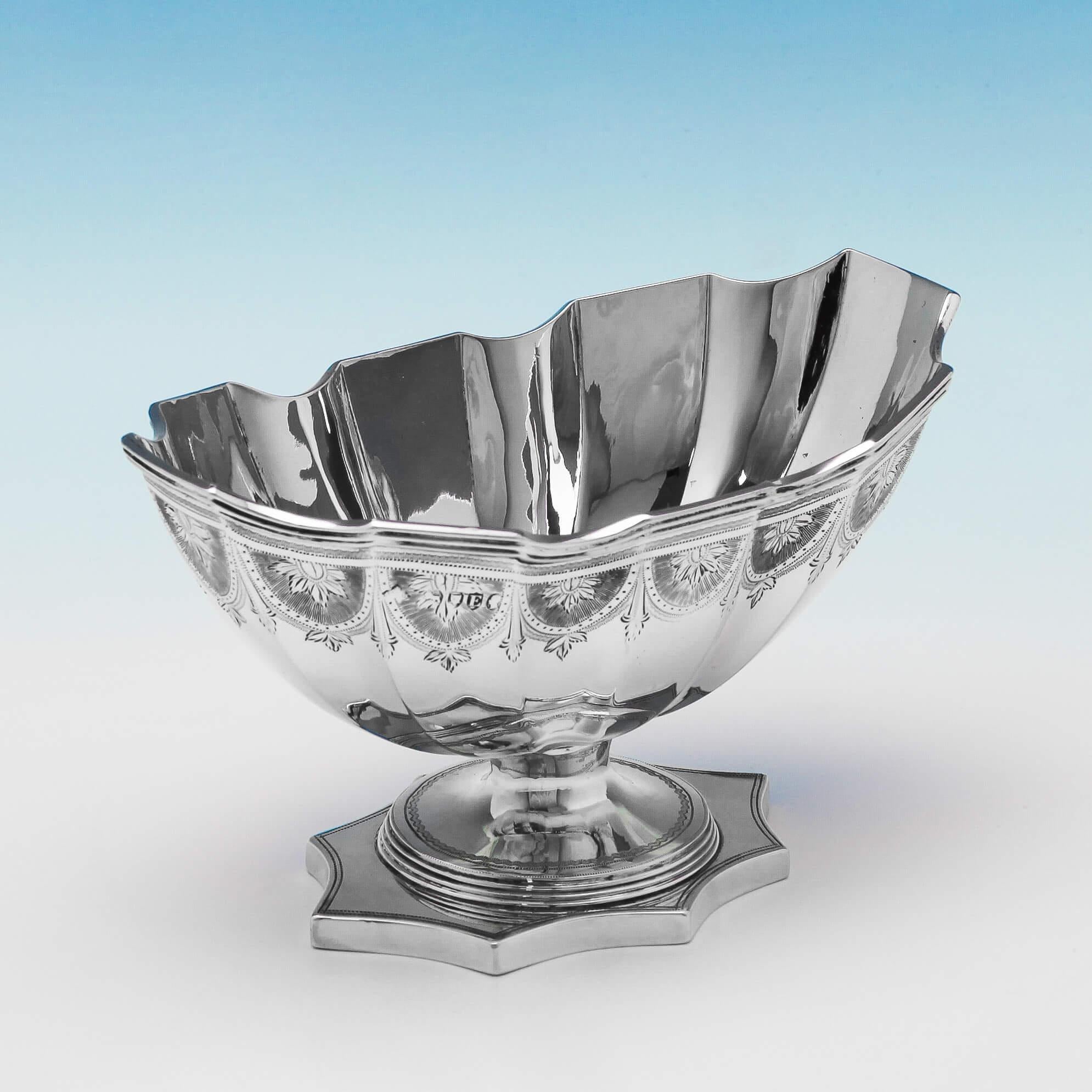 Hallmarked in London in 1880 by A. B. Savoury & Sons, this attractive, Victorian, antique sterling silver bowl, features bright cut engraved decoration, shaped sides, and stands on a scalloped pedestal foot. The bowl measures: 3.5 inches (8.5cm)