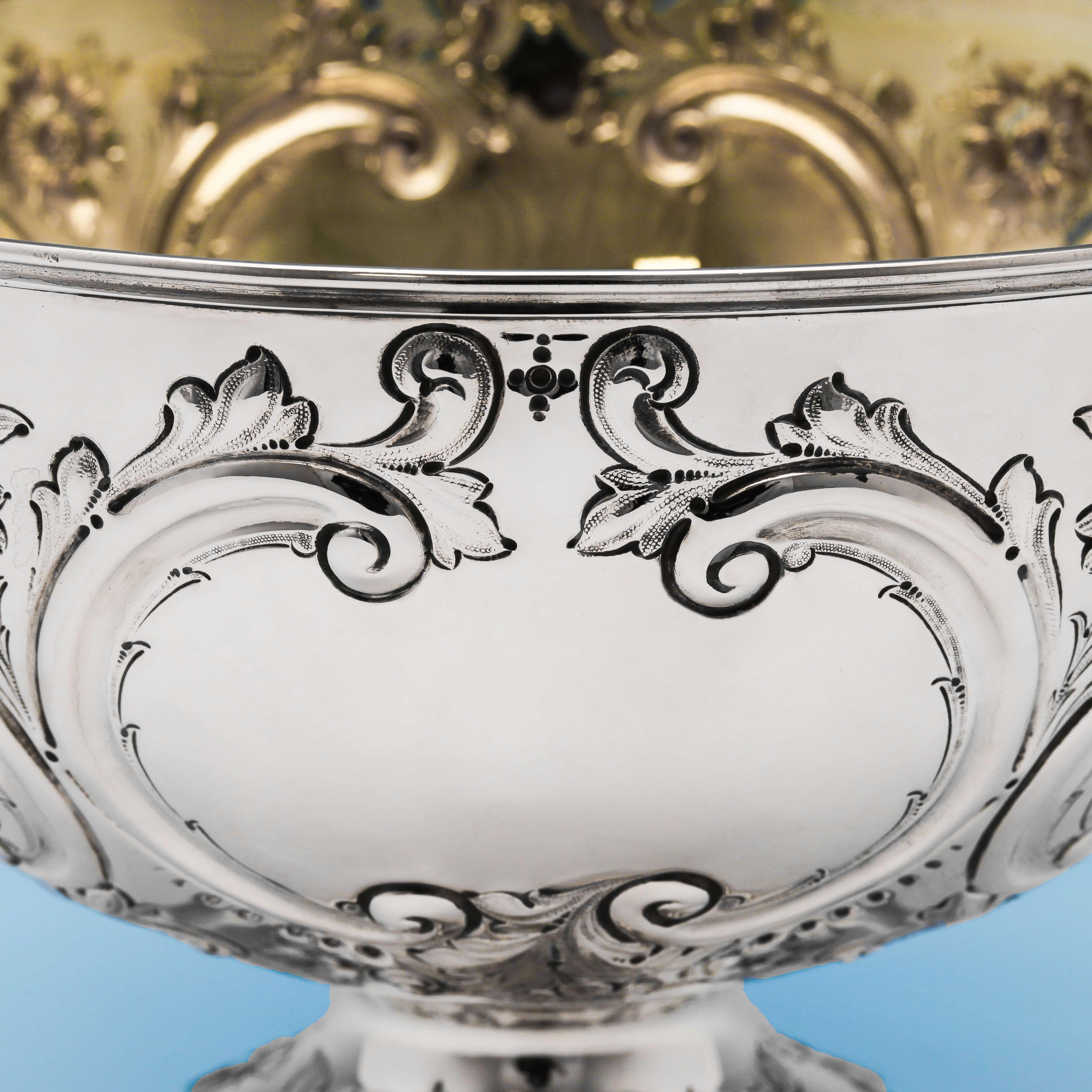 Hallmarked in London, in 1889 by Barnards, this attractive, Victorian, antique sterling silver bowl, features floral and scroll chased decoration throughout, and a gilt interior. The bowl stands on a pedestal foot and measures 7.5 inches (19cm) in