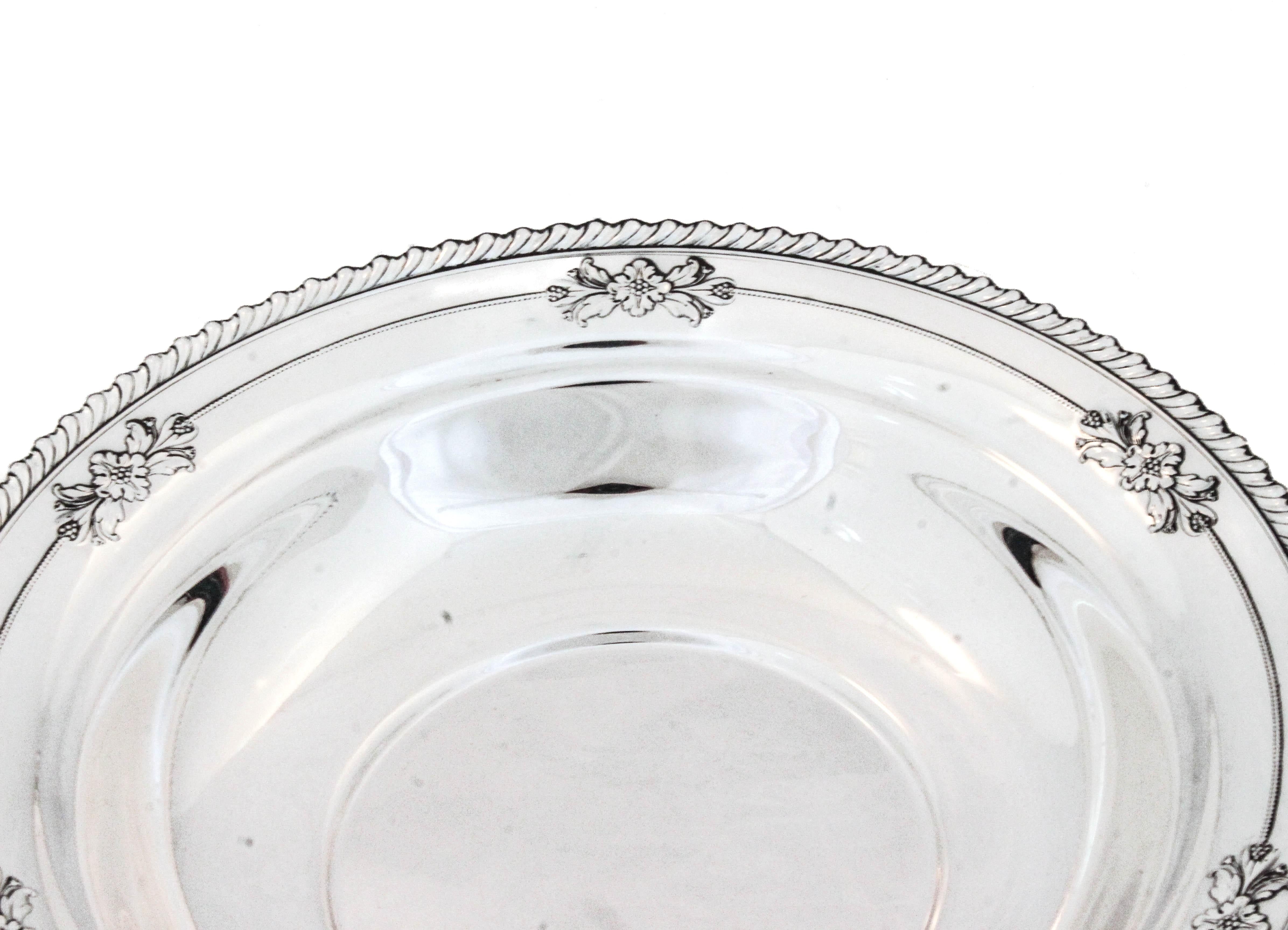 Viene offerta una ciotola in argento sterling realizzata da Wallace Silversmiths.  Ha un disegno a gadroon intorno al bordo con sei icone floreali uniformemente distanziate lungo il bordo interno.  Una dimensione ideale per un intrattenimento
