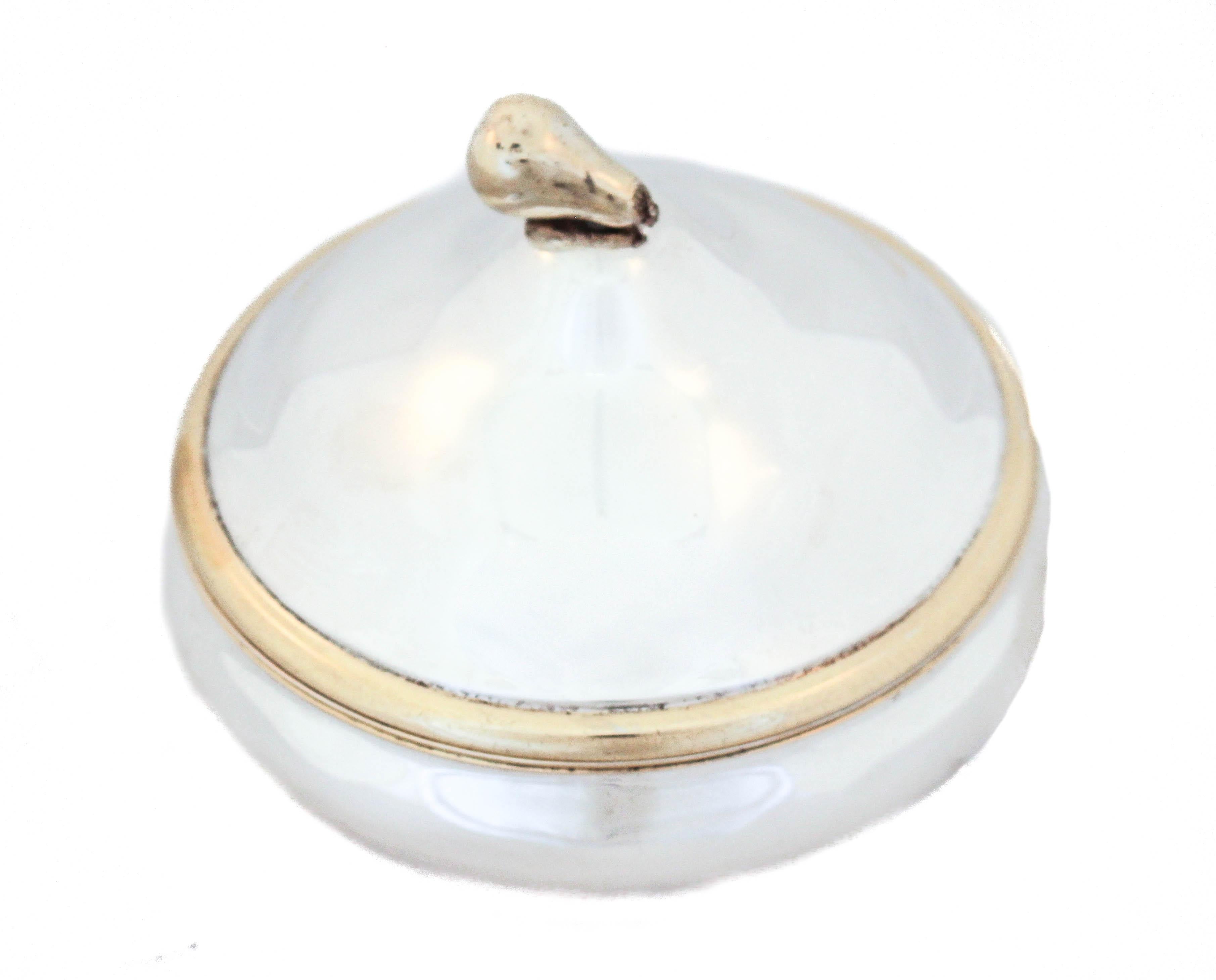 Being offered is a sterling silver round box with a domed lid. The finial is shaped like a pear and is gold washed as is the rim of the cover. The inside lid and bowl are gold washed as well.  This piece can be used for decorative purposes (on a