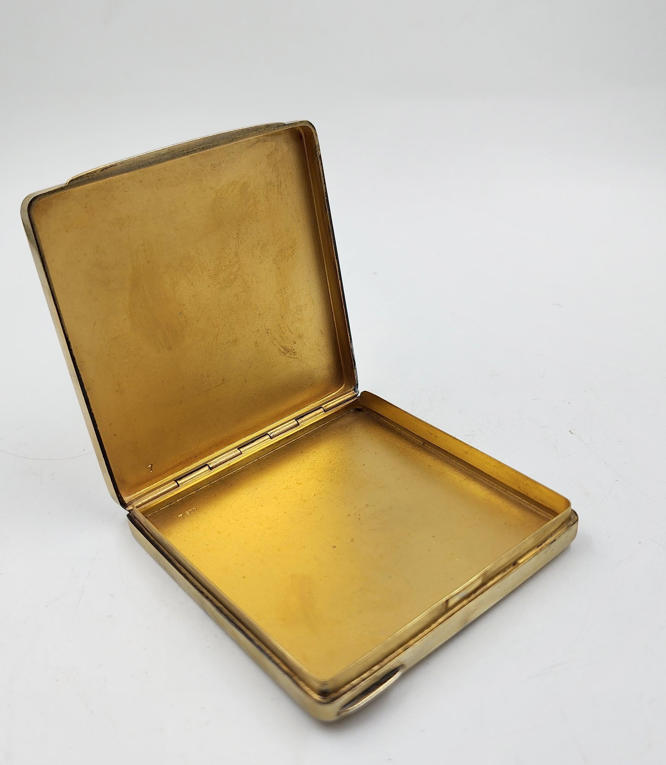Scatola in argento sterling con design smaltato
Questa scatola di forma quadrata con angoli smussati è realizzata in argento puro 800 millesimi e presenta un design smaltato e una placcatura in oro. Il coperchio presenta un pannello centrale in