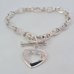 Pulsera de plata de ley con colgante de corazón y cierre basculante dorado