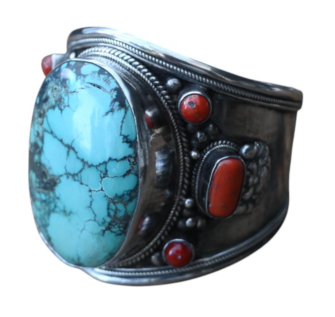 A heavy silver bracelet with natural red coral and large turquoise, Tibet/Nepal 19th century.
The silver is high quality silver but is not marked, but chemically tested.
Bracelet width 7 cm, inner diameter 67.5 x 65 mm, turquoise diameter 4 x 5.5