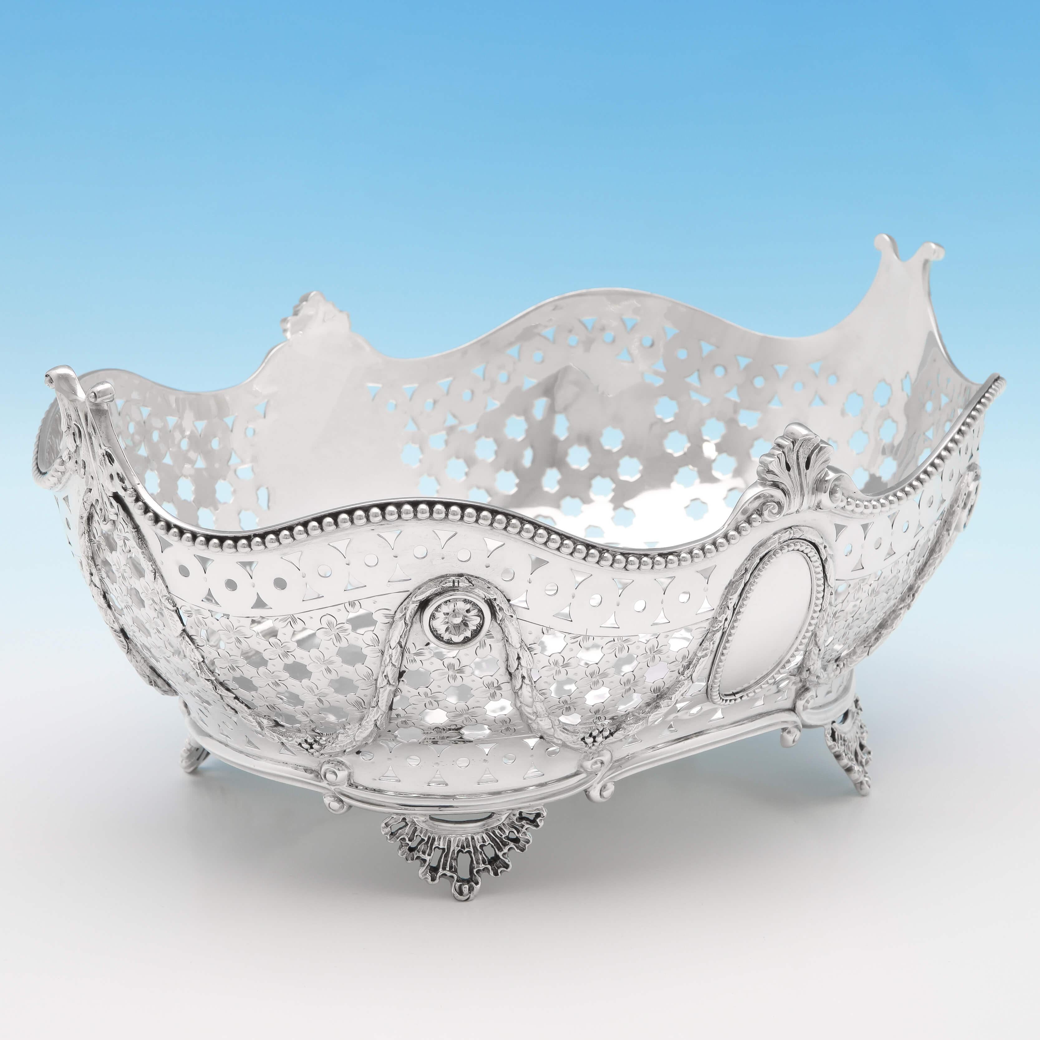 Hallmarked in London in 1886 by Job Frank Hall, this attractive, Victorian, antique sterling silver bread dish, features pierced decoration to the sides, a bead border, swags and garland detailing, and four cast and applied feet. The basket measures