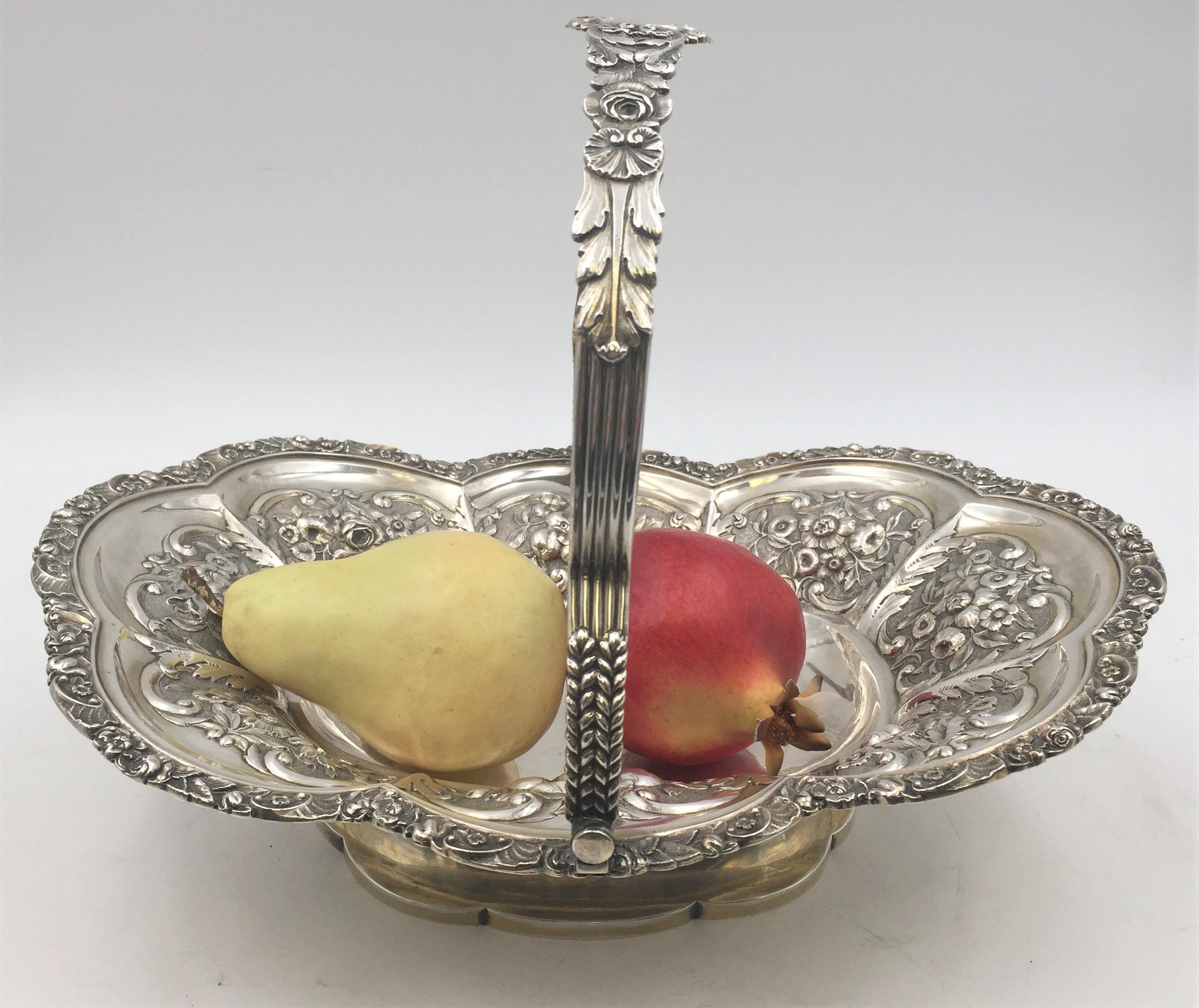 English silver basket bowl by Henry Herbert, from 1823, in detailed decorative floral design on basket and handle, standing on base. Measuring 9.8 inches tall, 13 inches long, and 10.2 inches wide. Weighing 30 troy ounces. Bearing hallmarks as