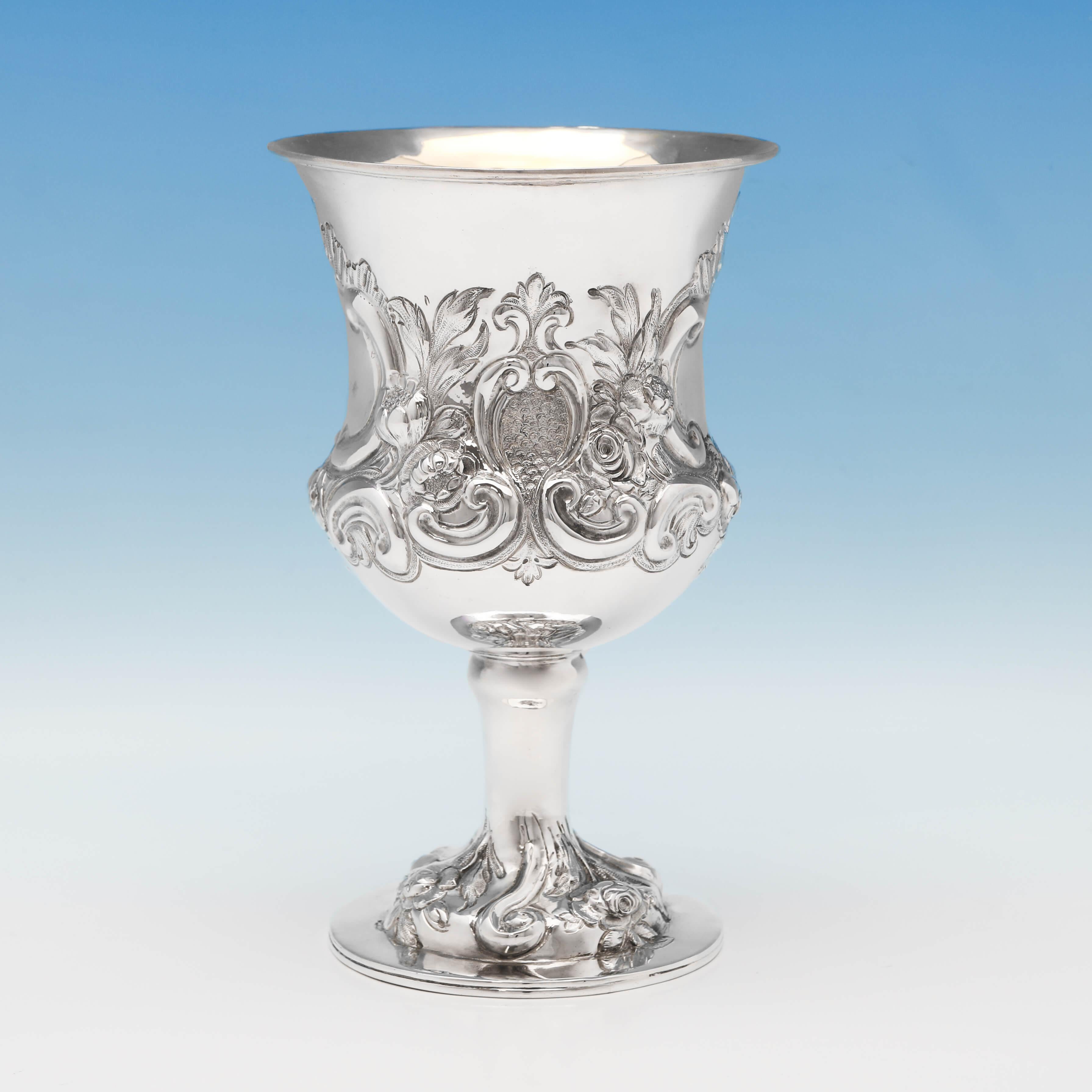 Hallmarked in London in 1864 by Charles Boyton, this attractive, Victorian, antique sterling silver goblet, is in the 'campagna' shape, and features a gilt interior, and chased floral and scroll decoration. The goblet measures: 7.5
