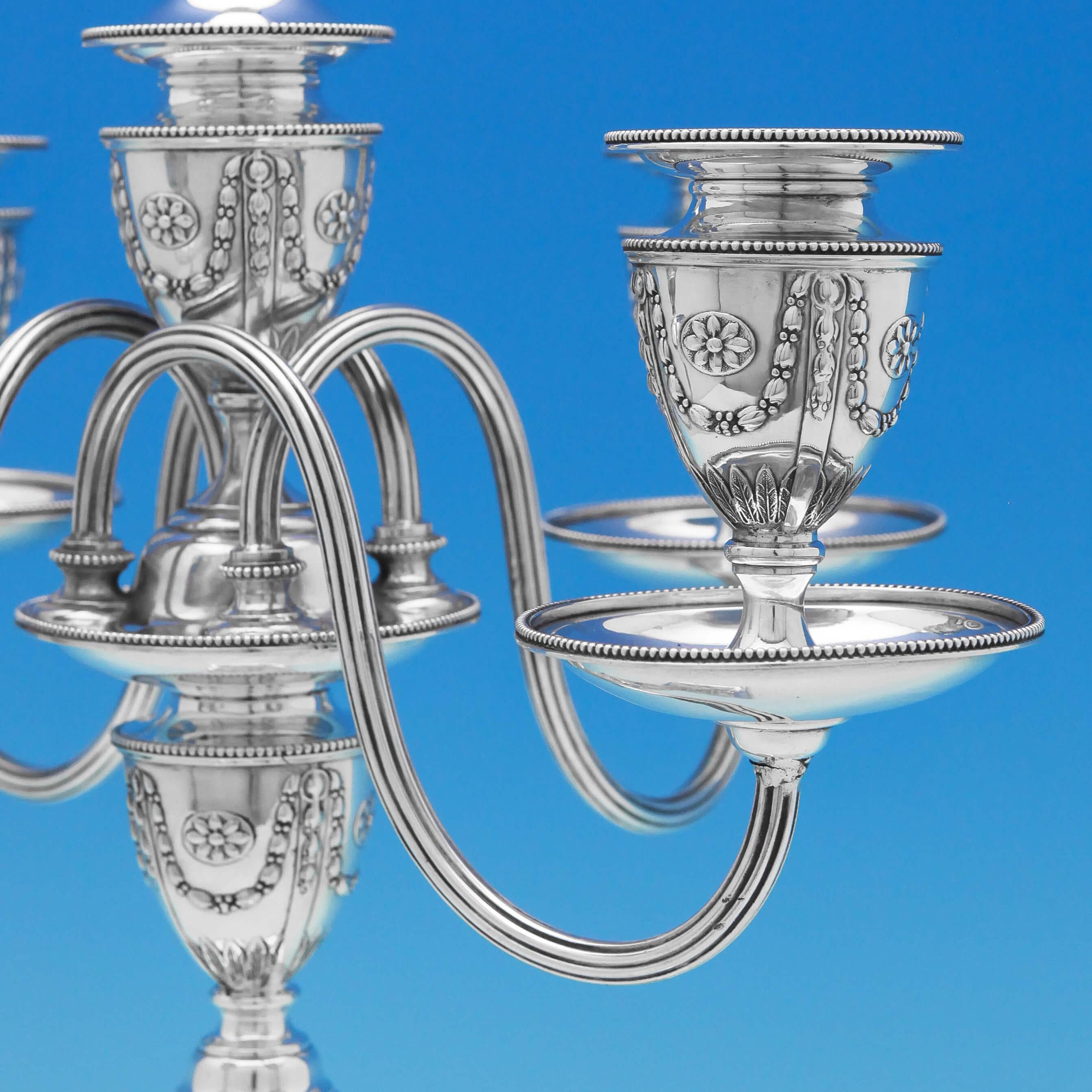 Hallmarked in London in 1890/1 by Elkington & Co., this spectacular pair of 5 light, Antique, Victorian, sterling silver candelabra are in the Adams Style, decorated with rams’ heads, swags and bows throughout. The branches are removable to allow