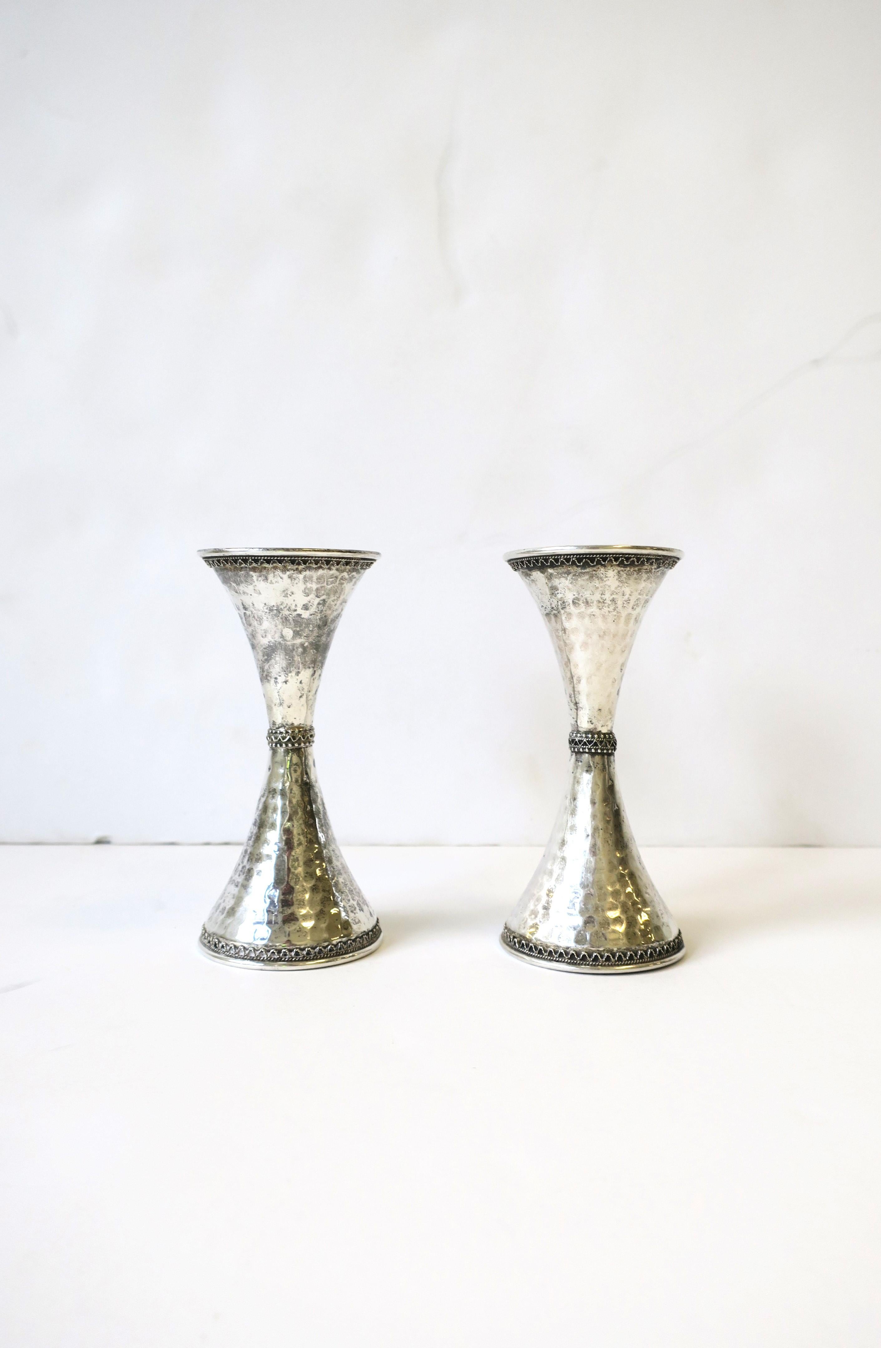 A beautiful pair/set of sterling silver candlestick holders, circa 20th century, Israel. Pair have an hourglass shape, hammered design and small intricate detail at top, center, and base area. Marked inside: 'Shevan Bros.' 'Sterling', '925', 'Made