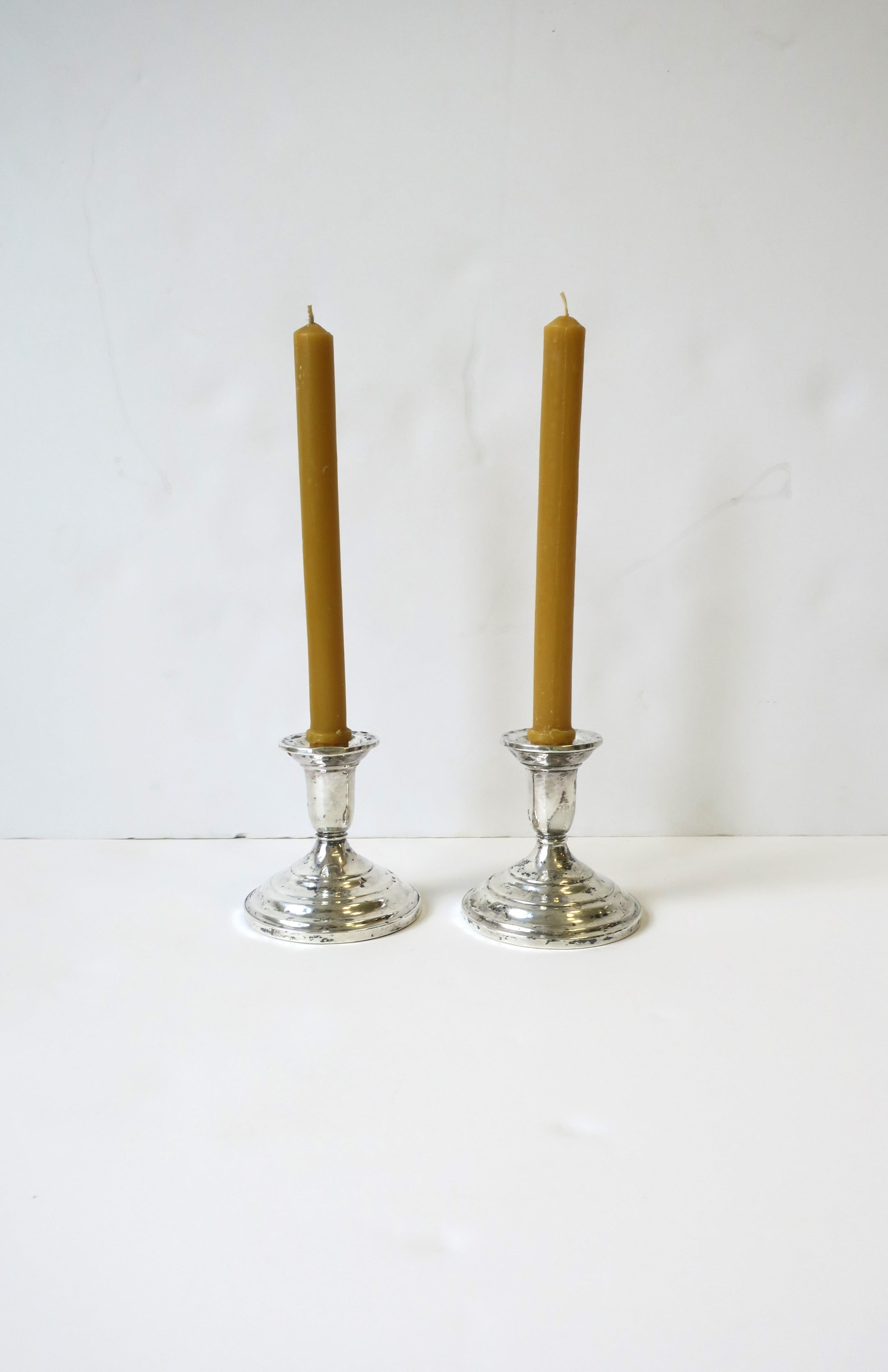 A pair of versatile sterling silver candlestick holders, circa 1960s, mid-20th century. A pleasure for any dining table. Makers' mark and marked 'Sterling' on bottom as shown. 

Dimensions: 3.44