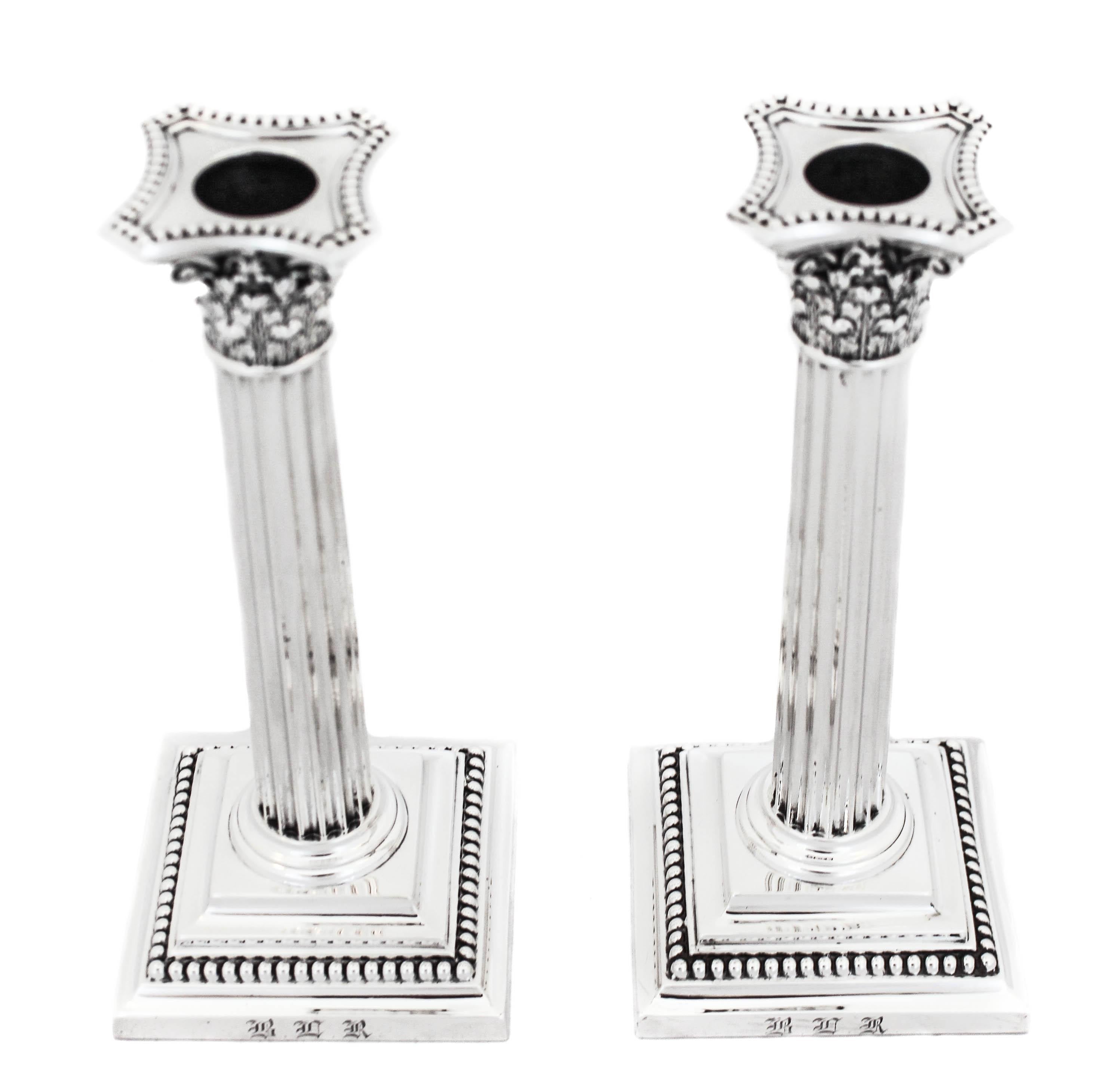 Being offered is a pair of candlesticks by Gorham Silversmiths, hallmarked 1923. They are designed as Corinthian Columns and have a square shaped base. Around the base a row of beads encircles the candlesticks. They have a real presence and will