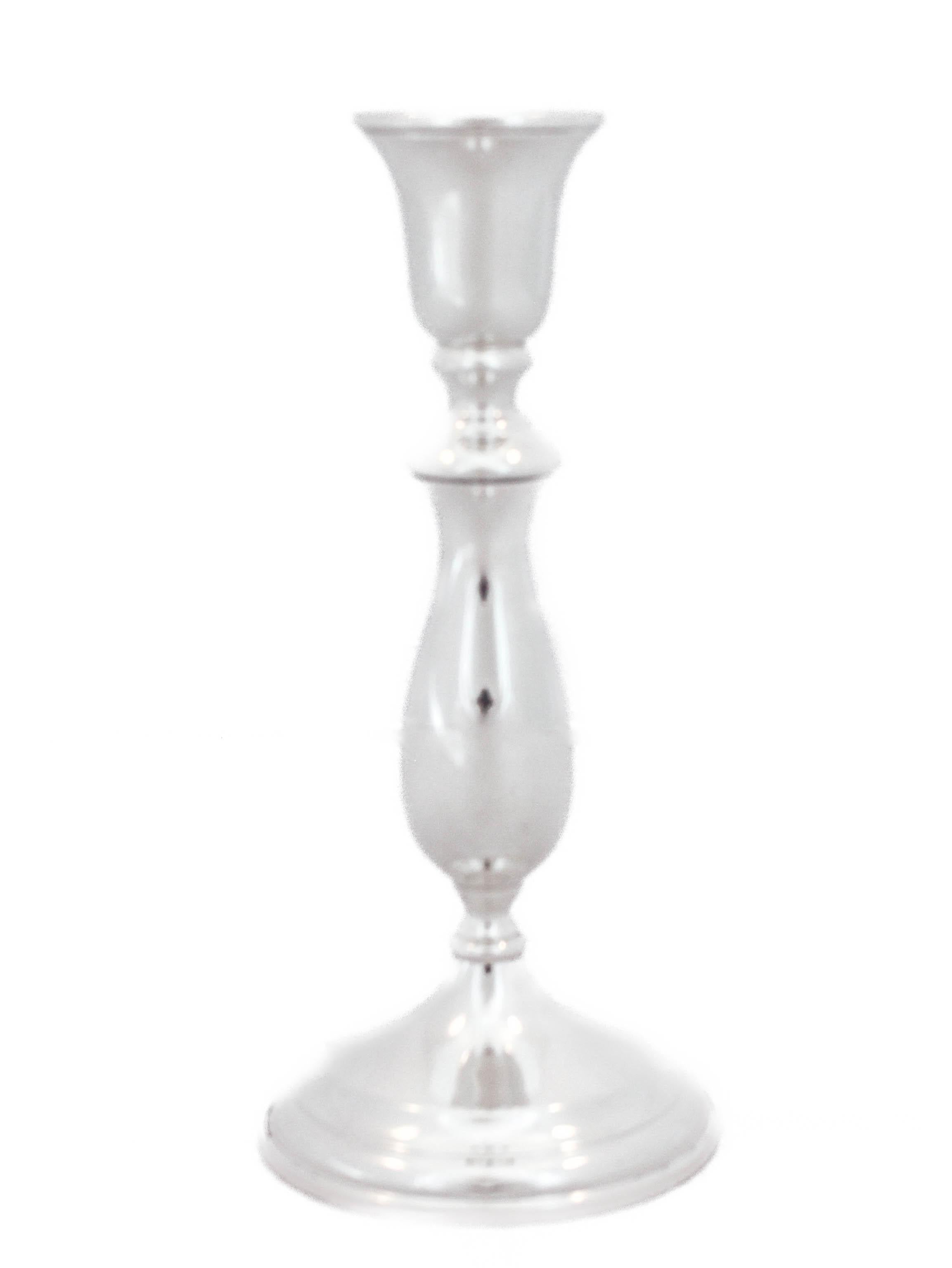 Se ofrece un par de candelabros de plata de ley de Redlich & Company.  Fabricados durante la Segunda Guerra Mundial, tienen una forma y un diseño austeros y sencillos.  Fue el periodo que precedió al movimiento 