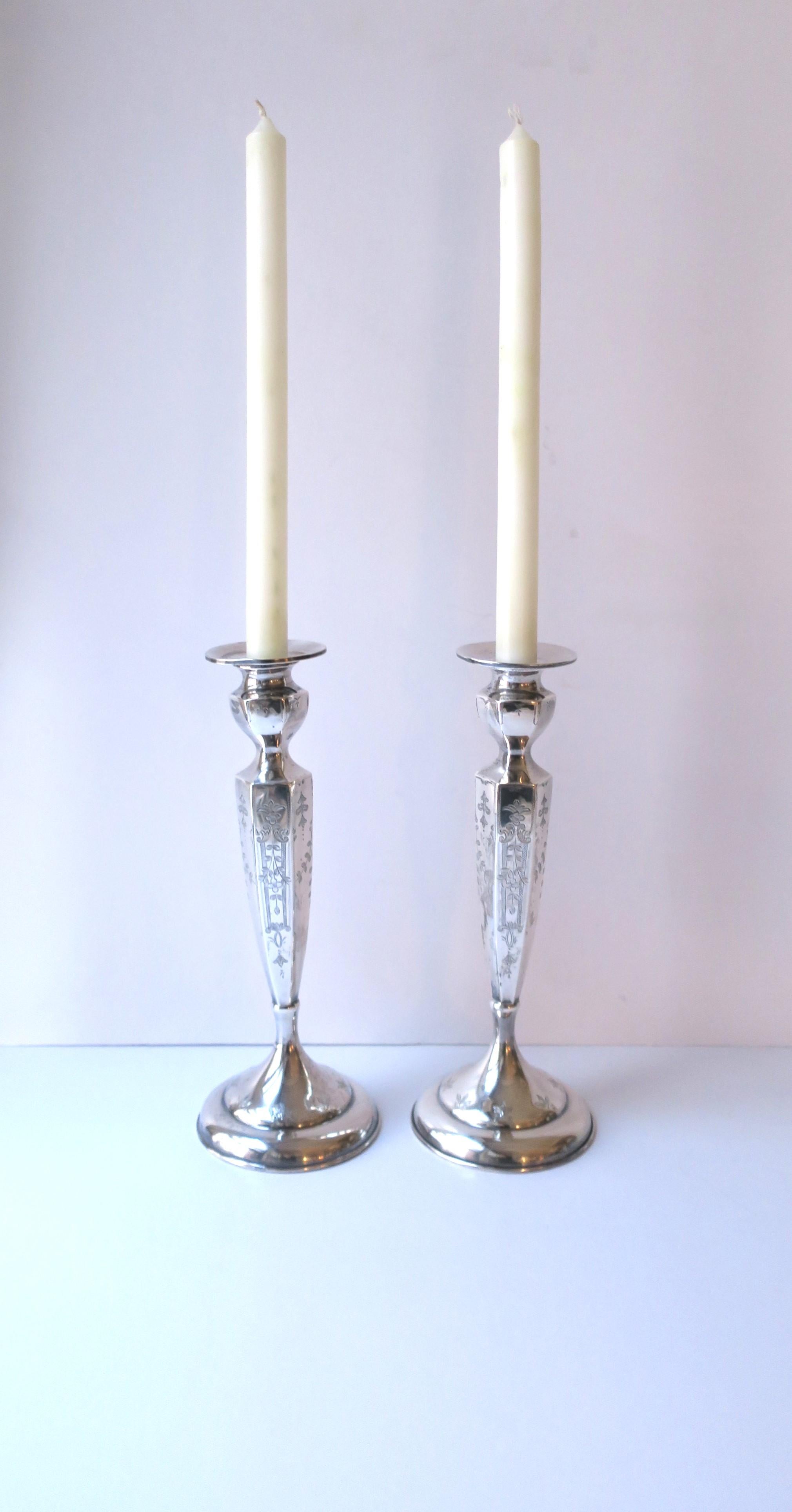 A beautiful pair of sterling silver candlestick holders, in the Victorian/Edwardian design, by J.E. Caldwell & Co., circa early-20th century, USA. A beautiful set with floral and leaf detail, hexagon shape and round base. A great set for a dining