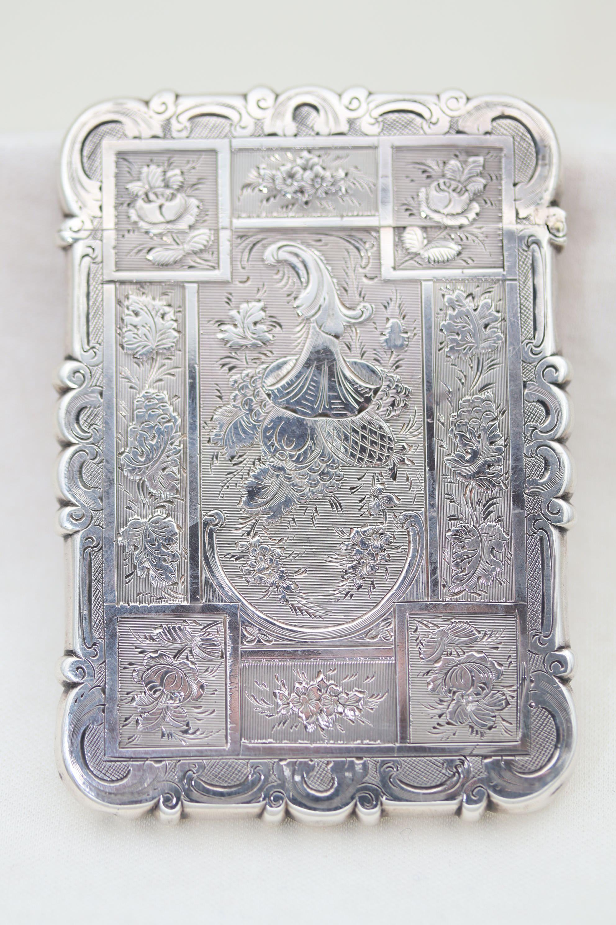 This good quality sterling silver card case was made by Edward Smith of Birmingham in 1854. Both sides are decorated with the same richly engraved pattern where the centre panel features a cornucopia of fruit and the surrounding panels depict