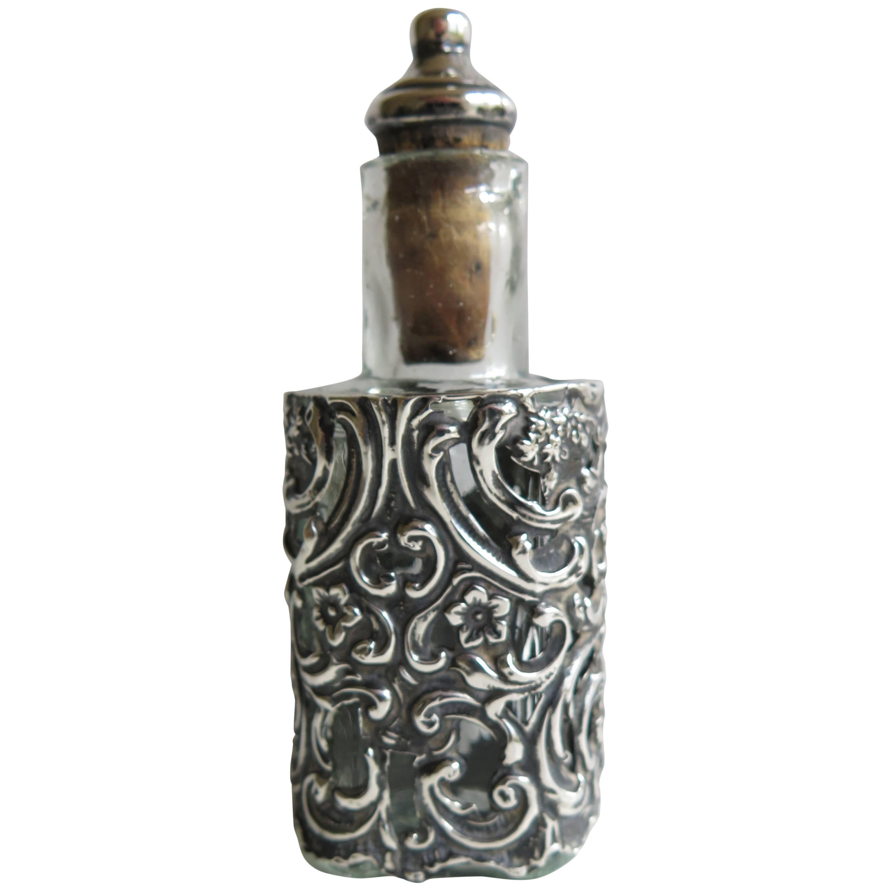 This is a high quality sterling silver cased glass perfume or scent bottle, made in Edwardian England in 1904

The pressed glass bottle is rectangular with curved sides and carries the name; Johann Grossmith to one side.

The glass bottle is