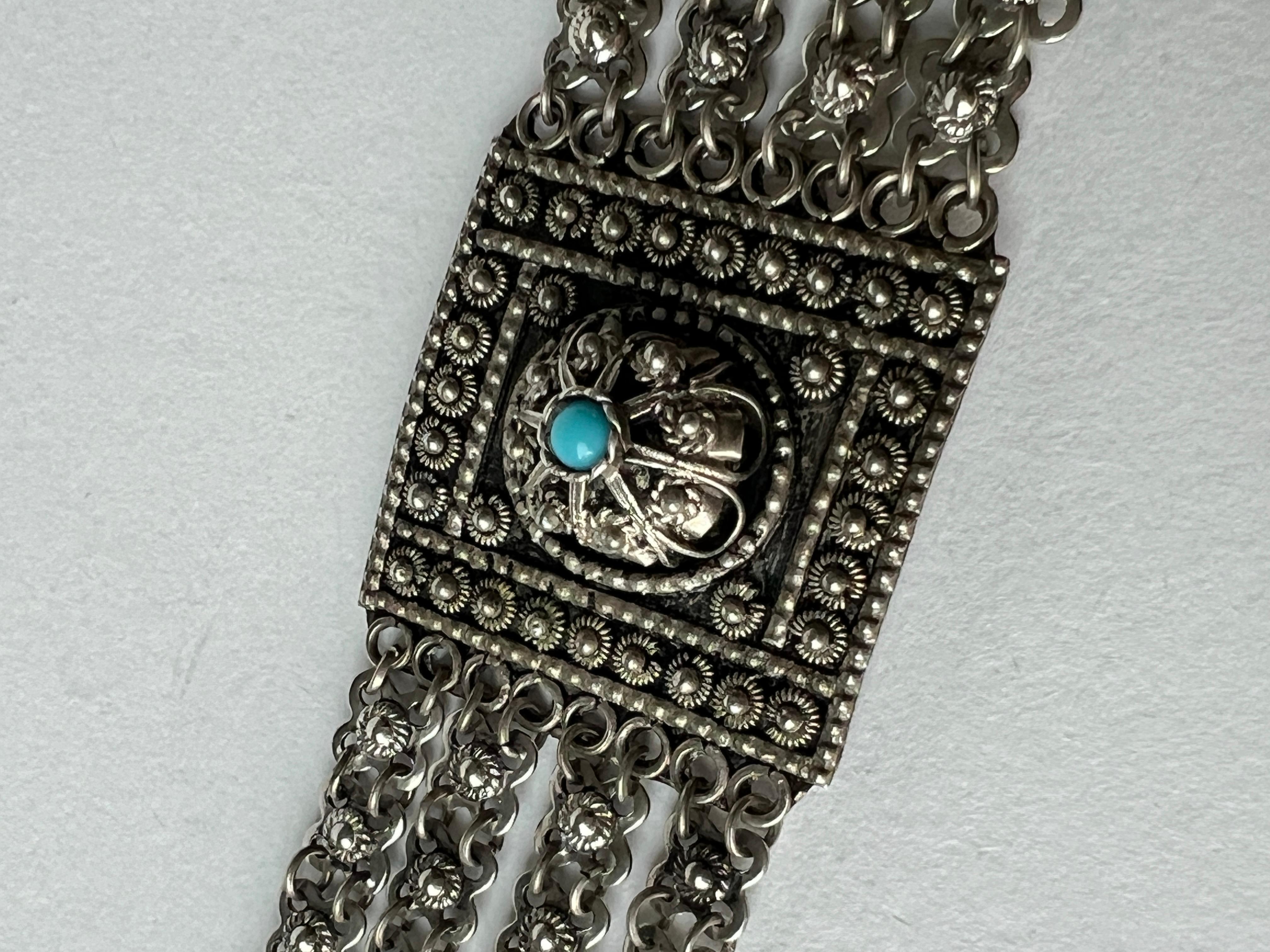 Vintage bracelet with an intricate design featuring plates with caviar texture and turquoise stones alternating with four rows of chains. Solid feel, sophisticated and unique. Reminiscent of Persian designs.

Weight: 0.95 oz (27 grams)
Size: 7.25