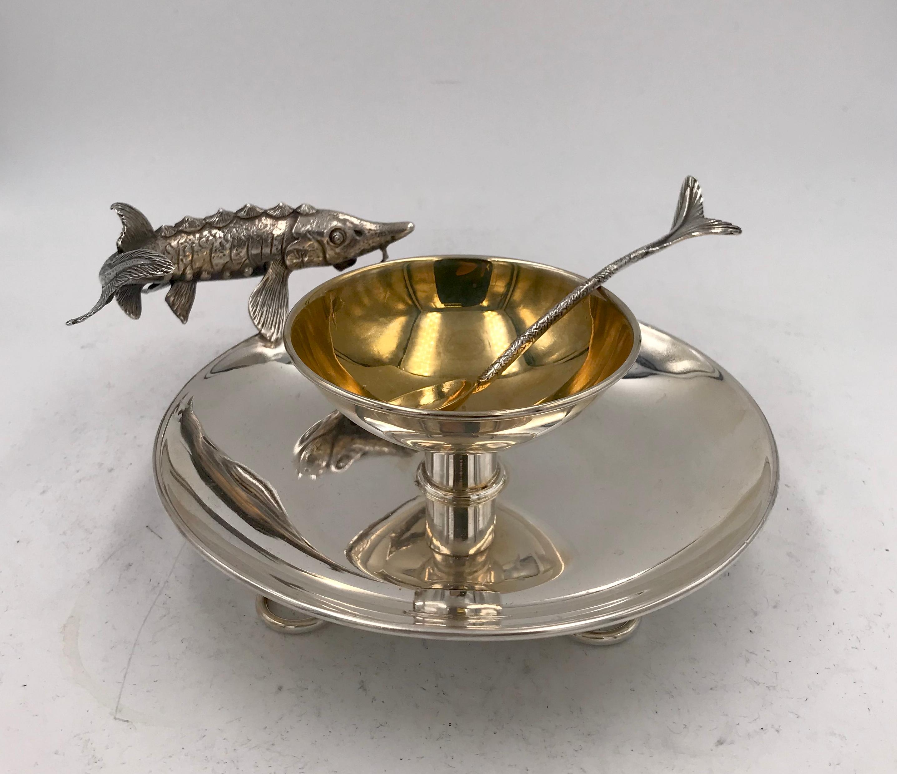 Sterling silver caviar dish and spoon, the bowl with gilded interior.
This lovely little dish has a sturgeon as the handle, and the accompanying spoon has a fish tail handle.