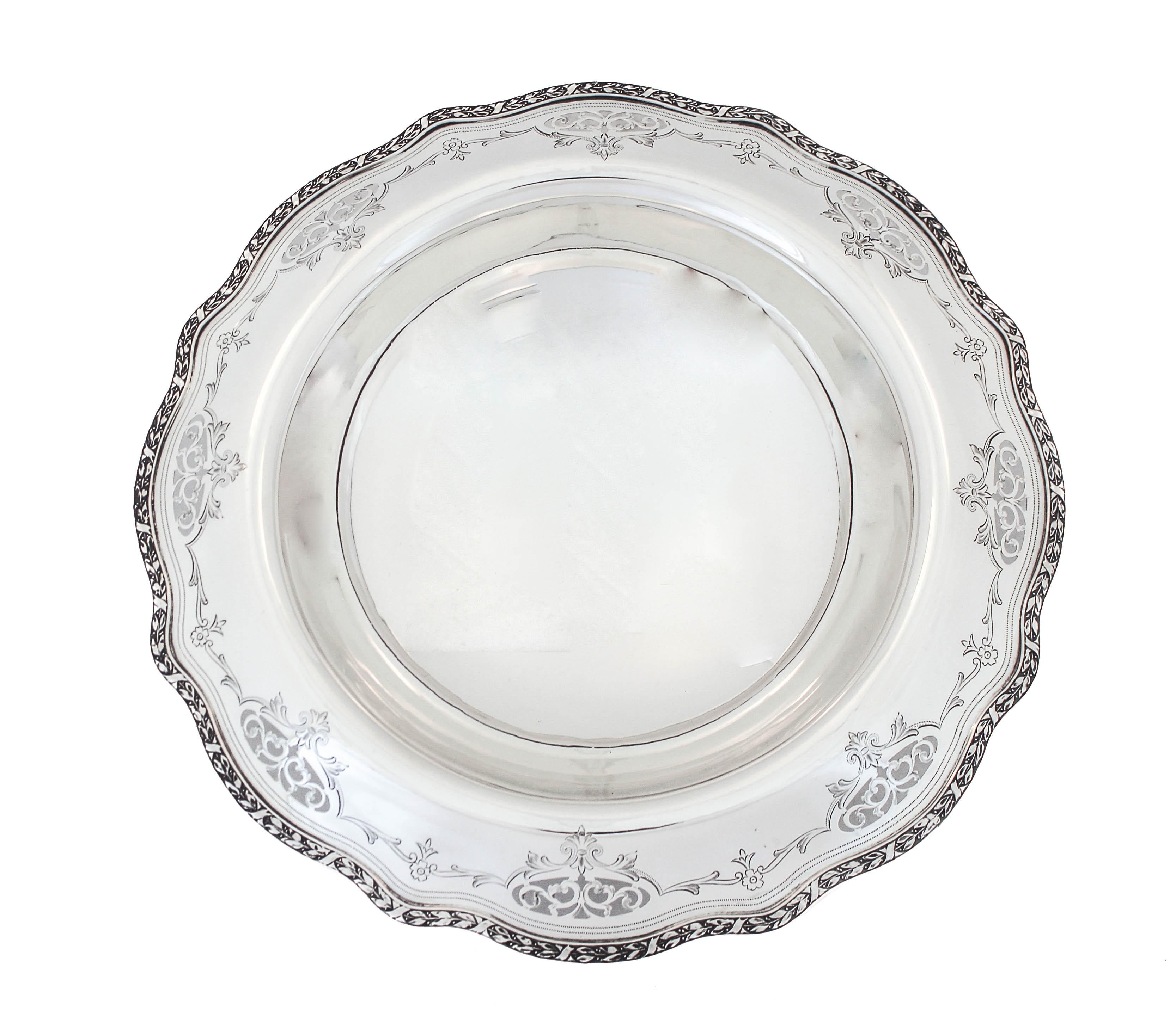 Being offered is a sterling silver centerpiece bowl made by Wallace Silversmiths from the mid nineteenth century.  It is raised on a pedestal and has a wide two-inch rim that is scalloped and has a cutout design.  Even when filled the beautiful edge