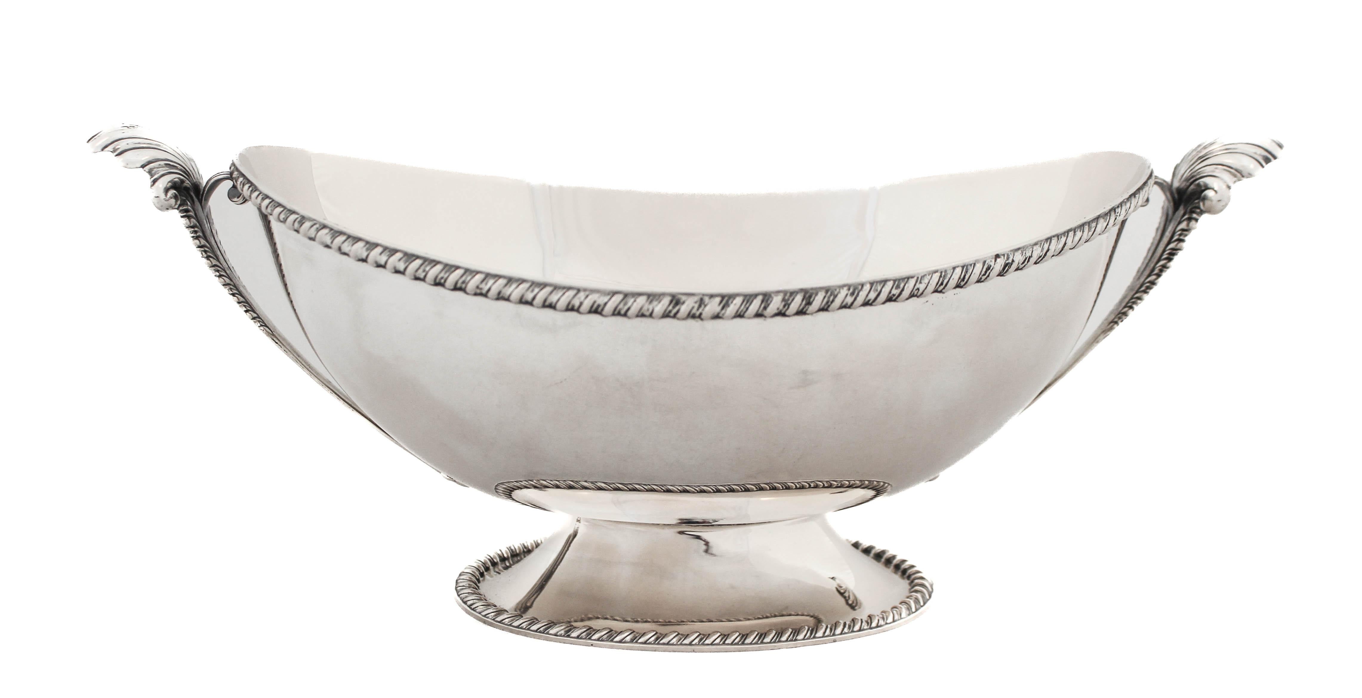 Being offered is a sterling silver centerpiece made in Austria.  It has a gadroon design around the base as well as the top rim.  Two handles in each end have a decorative shell on the top.  The shells curve outwards complimenting the shape of the