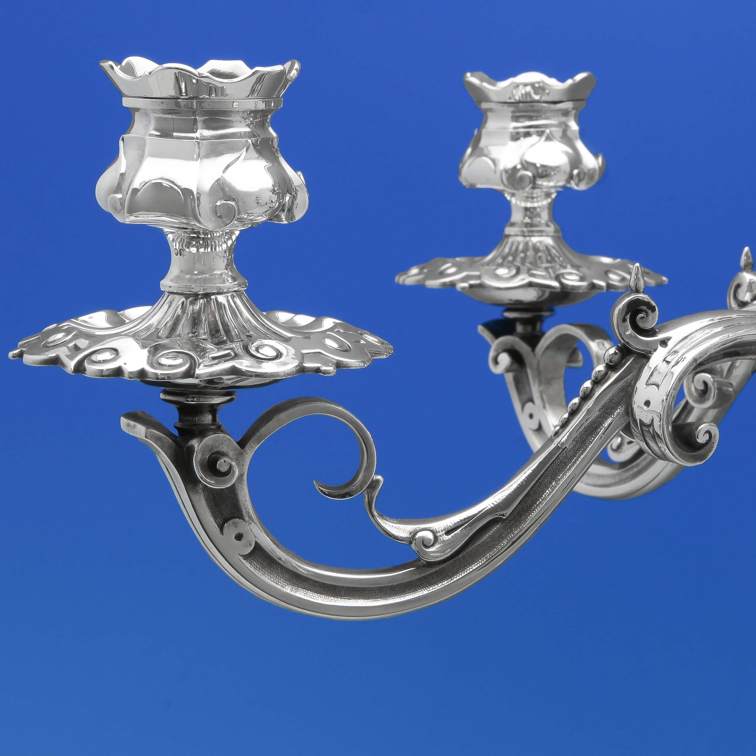 Marcado en Londres en 1854 por Barnards, este impresionante centro de mesa victoriano de plata de ley antigua tiene un cuenco central de cristal y 5 espacios para velas. La pieza central está ricamente decorada, con motivos de conchas y volutas, y