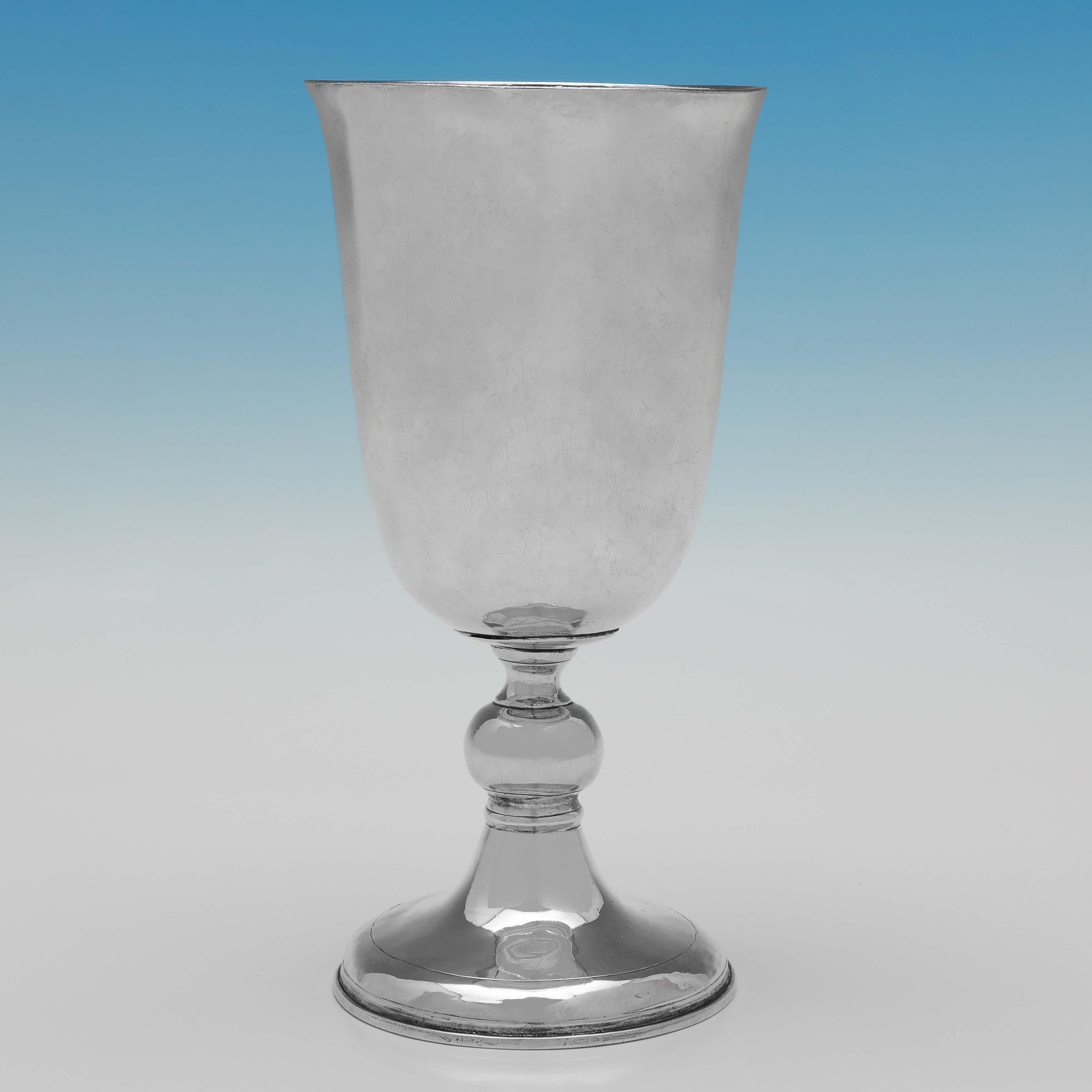 Hallmarked in London in 1705 by William Gamble, this outstanding, Queen Anne period, antique sterling silver chalice, is plain in style, standing on a pedestal foot detailed with reed borders. The chalice measures 7.5