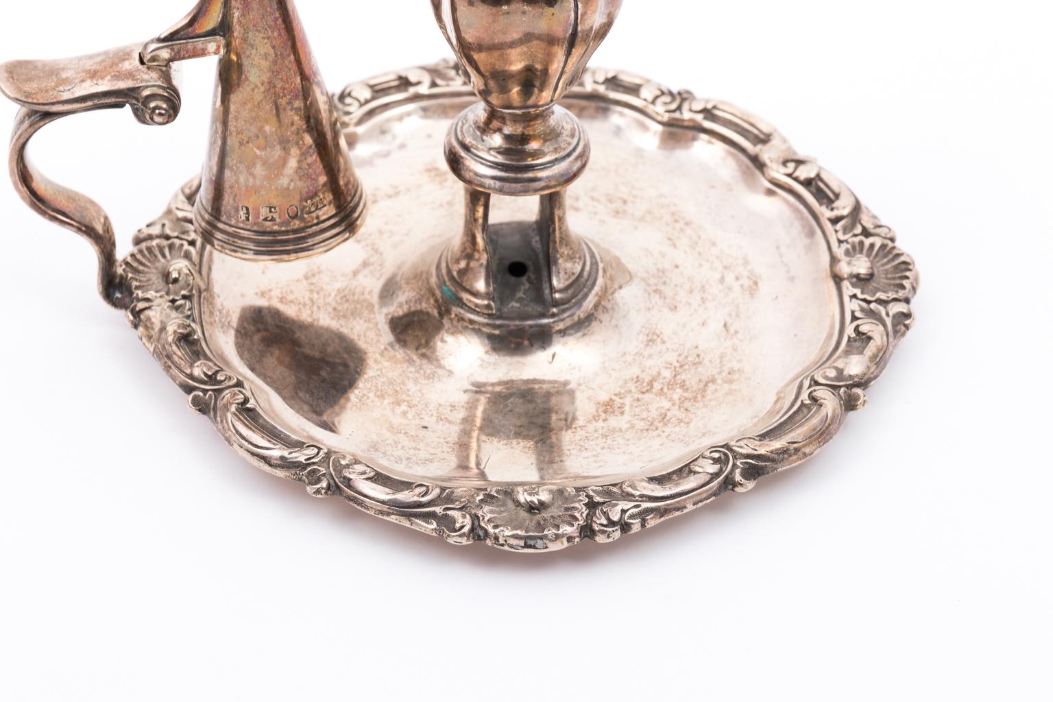 Sterling Silver chamber stick with candle snuffer, circa early 20th century. The hallmarks are possibly for Sheffield, England including a Maker's Mark, Lion Passant, Sovereign Head, and Crown with a P. The chamber stick weighs 315.20 Grams or 10.12