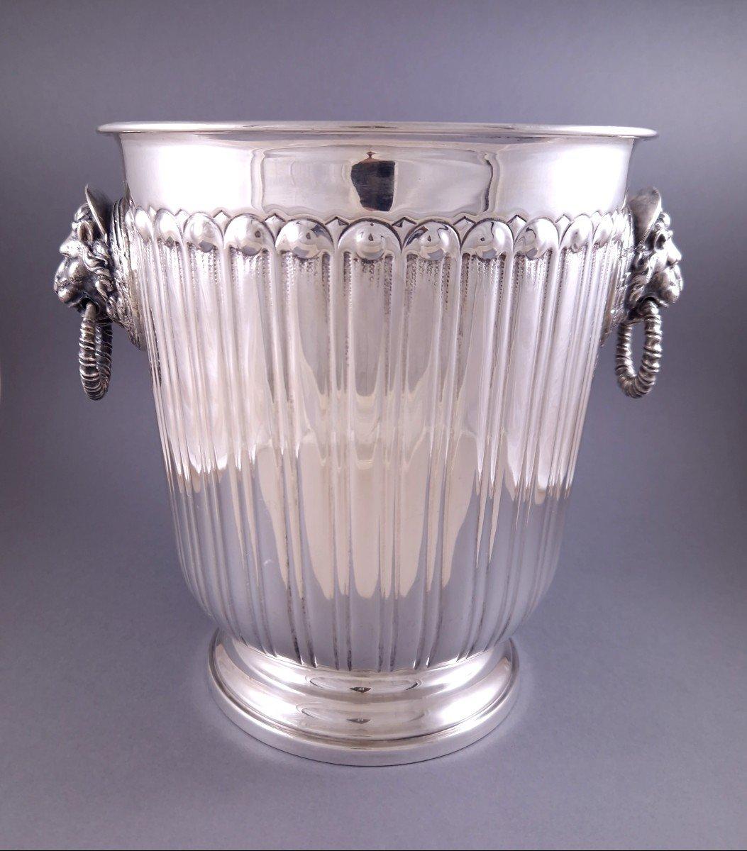 Champagne bucket in sterling silver decorated with flutes, the grips in the shape of lion heads 
Italian work from the 20th century 
800 Silver hallmark
Height: 22 cm 
Diameter without the grips: 19.6 cm 
Weight: 1055 grams
