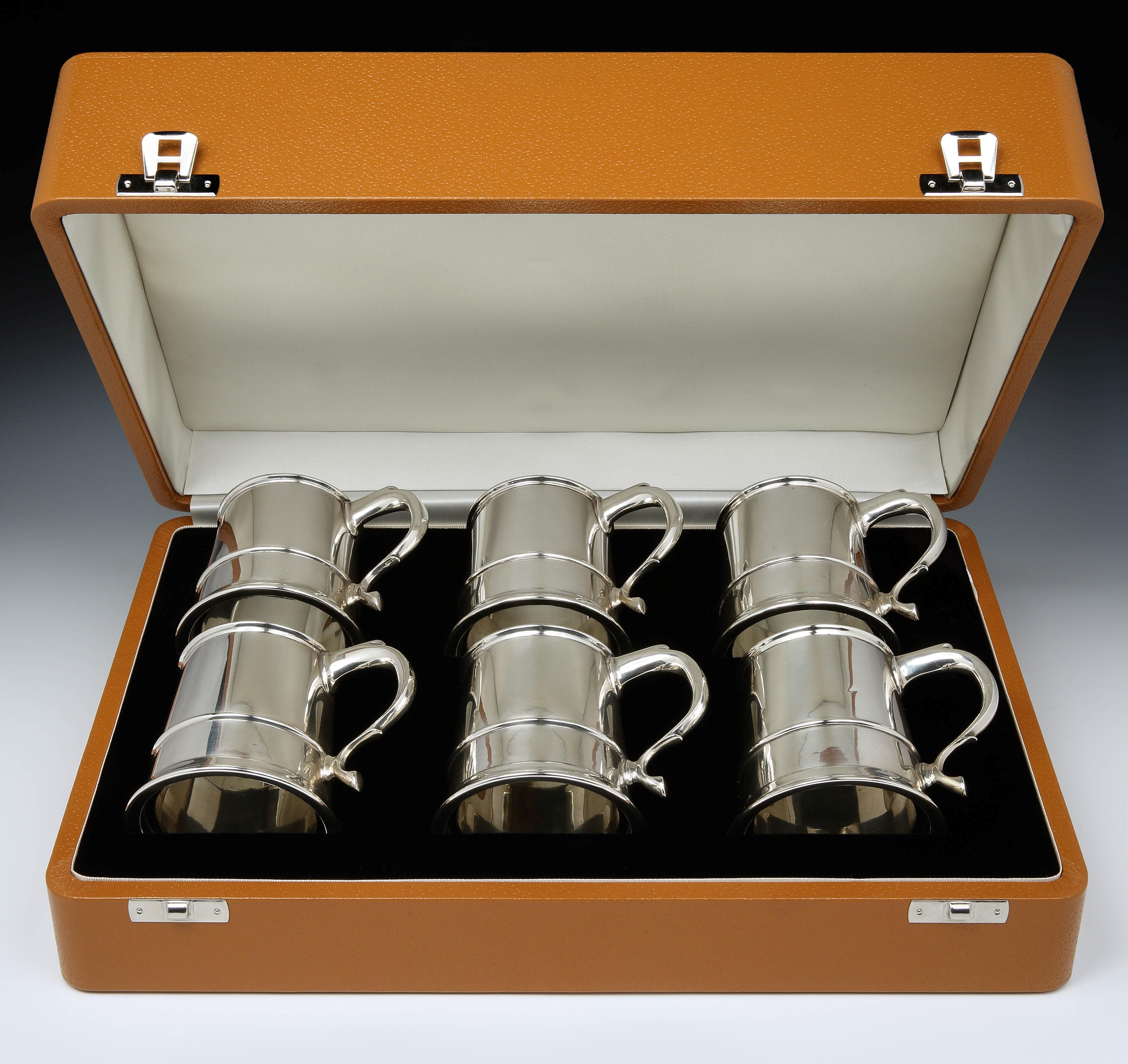 E W Haywood of Birmingham.

A set of six unusual and perfectly proportioned Sterling silver Champagne tankards, each of approximately half-pint capacity, with a tapered body and swept handle, each tankard with a clear glass base. Hallmarked E.W.H
