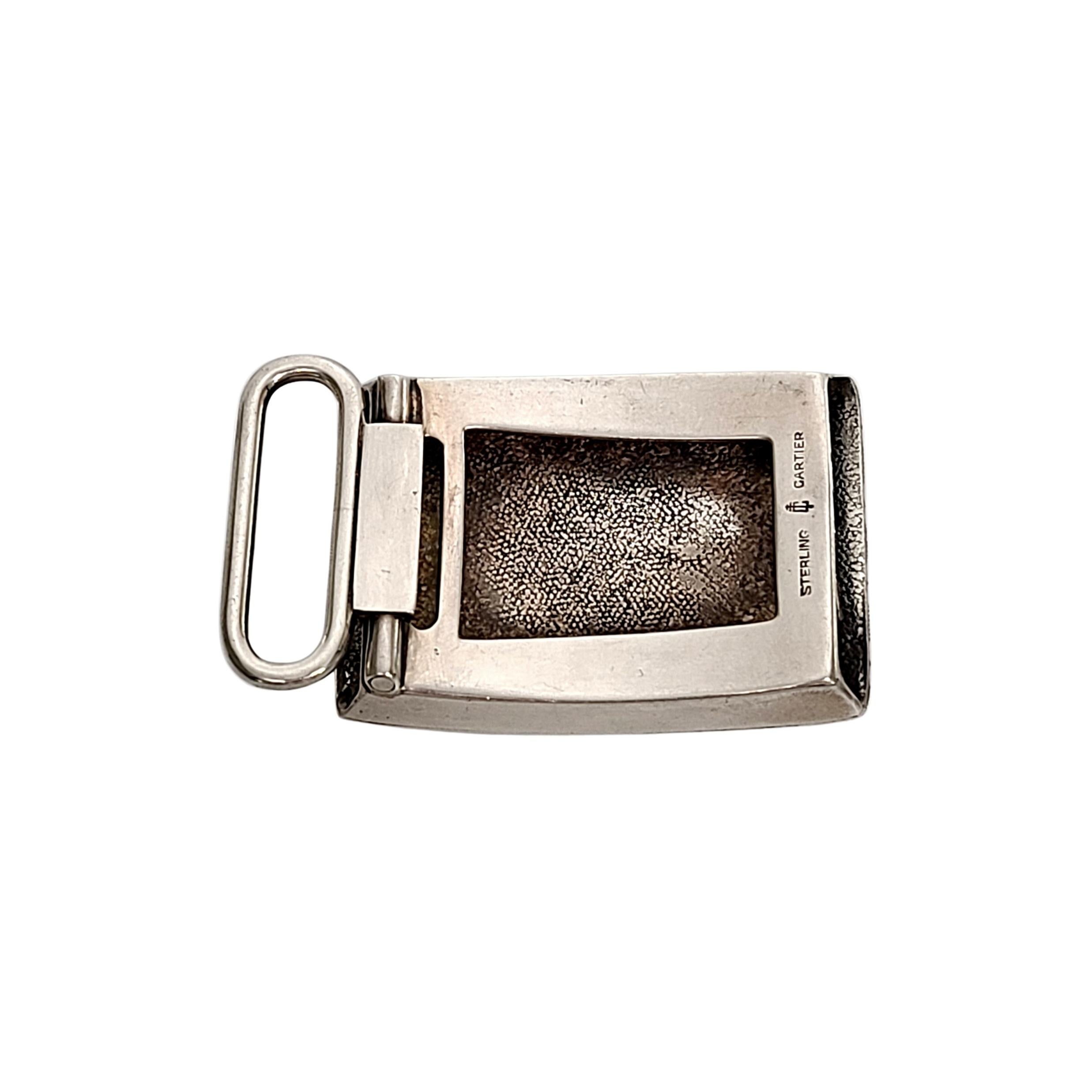 Sterling silver engine turned belt buckle by Charles Thomae for Cartier with monogram.

Rectangle shaped sterling silver belt buckle with engine turned etched stripe design. Rectangle cartouche at center with monogram.

Monogram appears to be