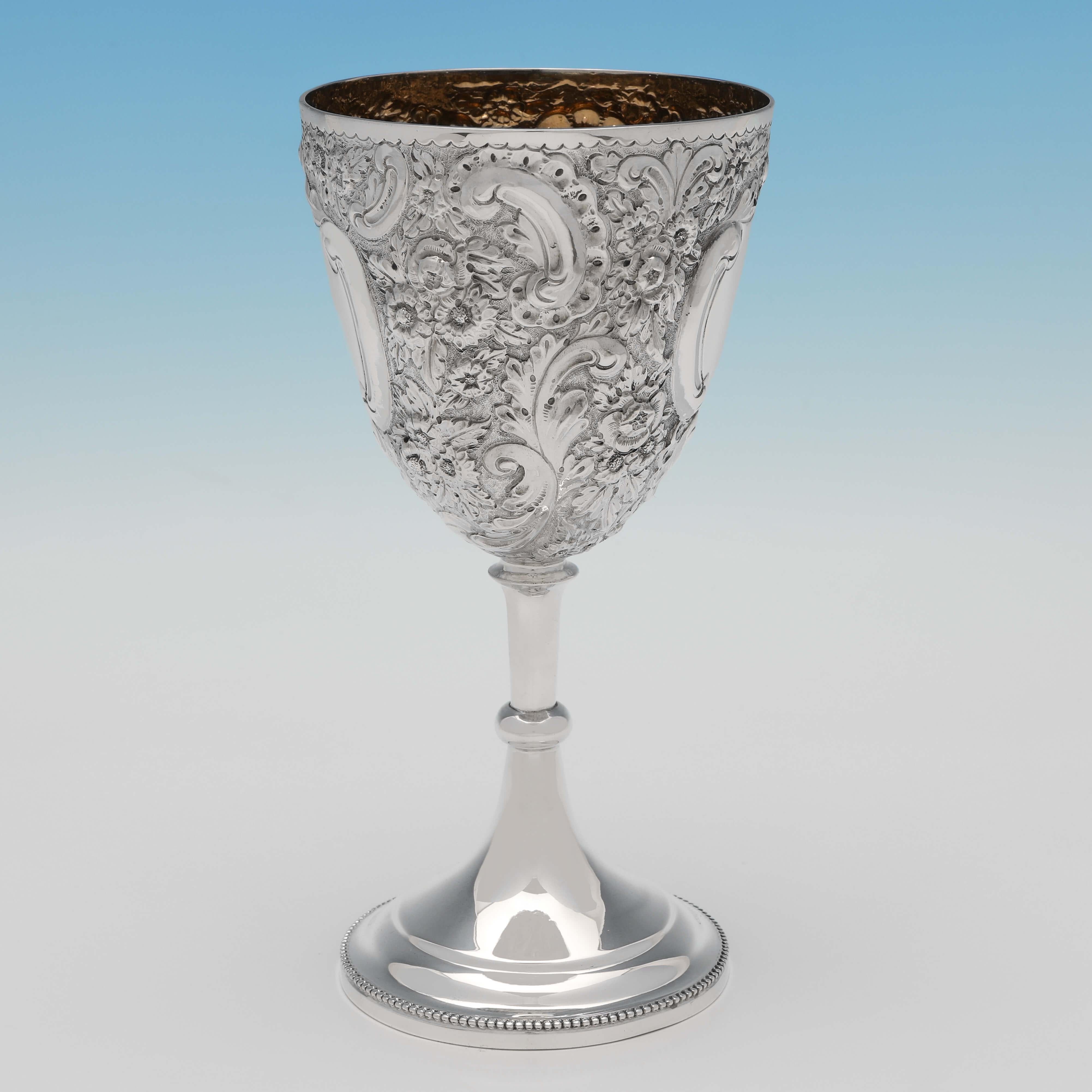 Hallmarked in Birmingham in 1894 by Nathan & Hayes, this attractive, Victorian, Antique Sterling Silver Goblet, is richly decorated with chased floral detailing, and has a gilt interior. The goblet measures 7.75