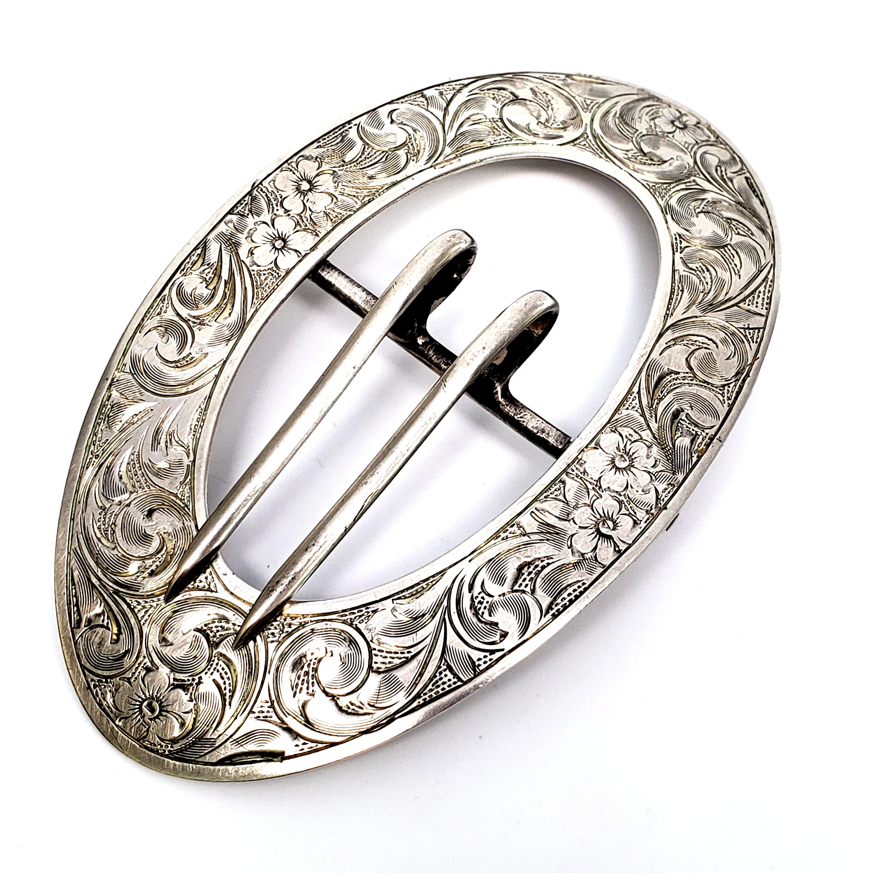 Vintage large, oval sterling silver belt buckle.

Beautiful chased and respousse design with floral and scroll patterns.

Measures 3 15/16