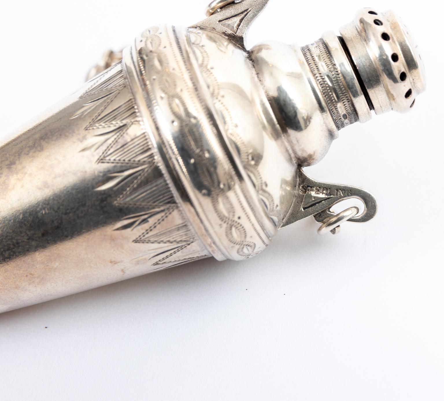 Engraved sterling silver chatelaine perfume vinaigrette decorated with beaded and geometric trim, circa 1890s-1920s. The piece measures 3.25 inches height excluding the chain, the width is 1.50 inches including handles and the depth is 1.25 inches.