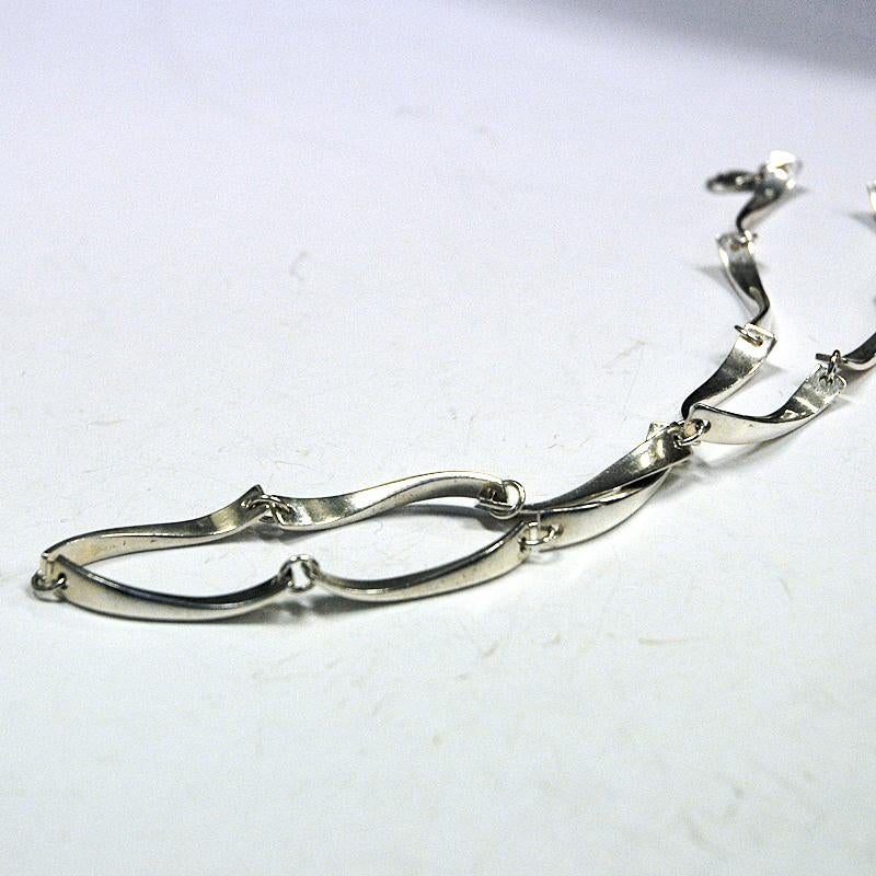 Lovely silver necklace with wave shaped bars chained together by designer Jaana Toppila-Ikalainen -Finland 1998. The silver bars has a twisted shape. Natural patina and good vintage condition. Signed JTI - 925, Finland V8.
Measure: Lenght of bars: