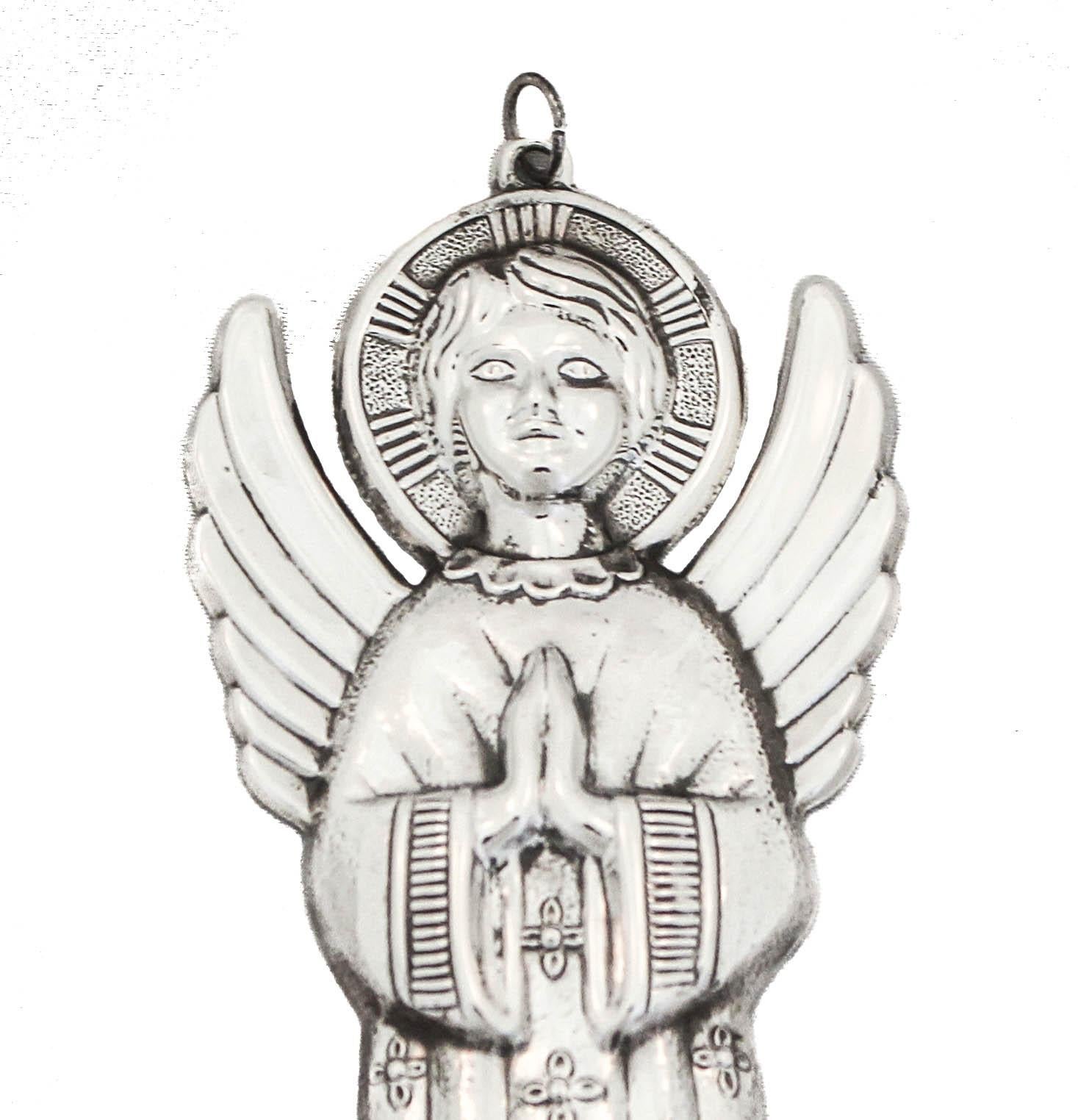 Being offered is a sterling silver Christmas ornament made by Gorham Silversmiths of Providence, Rhode Island, circa 1983.  It is of an angel praying with its hands together.  It has wings and a halo around its head and a cross pattern on its robe. 