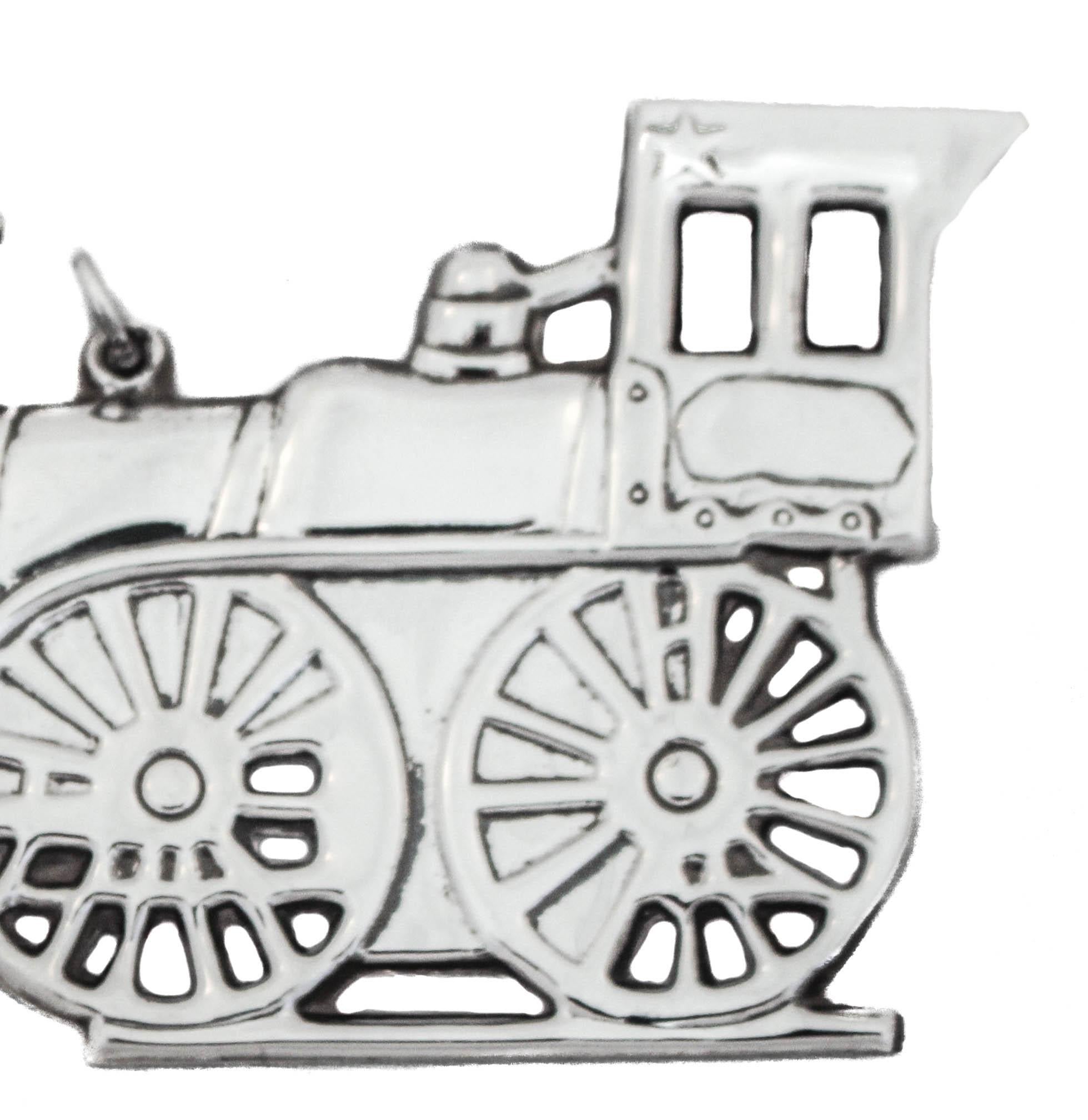 Being offered is a sterling silver Christmas ornament of a (choo-choo)locomotive train made by Gorham Silversmiths and signed 1976.  
The connection between toy trains and Christmas comes from a time when people traveled long distances to reach home