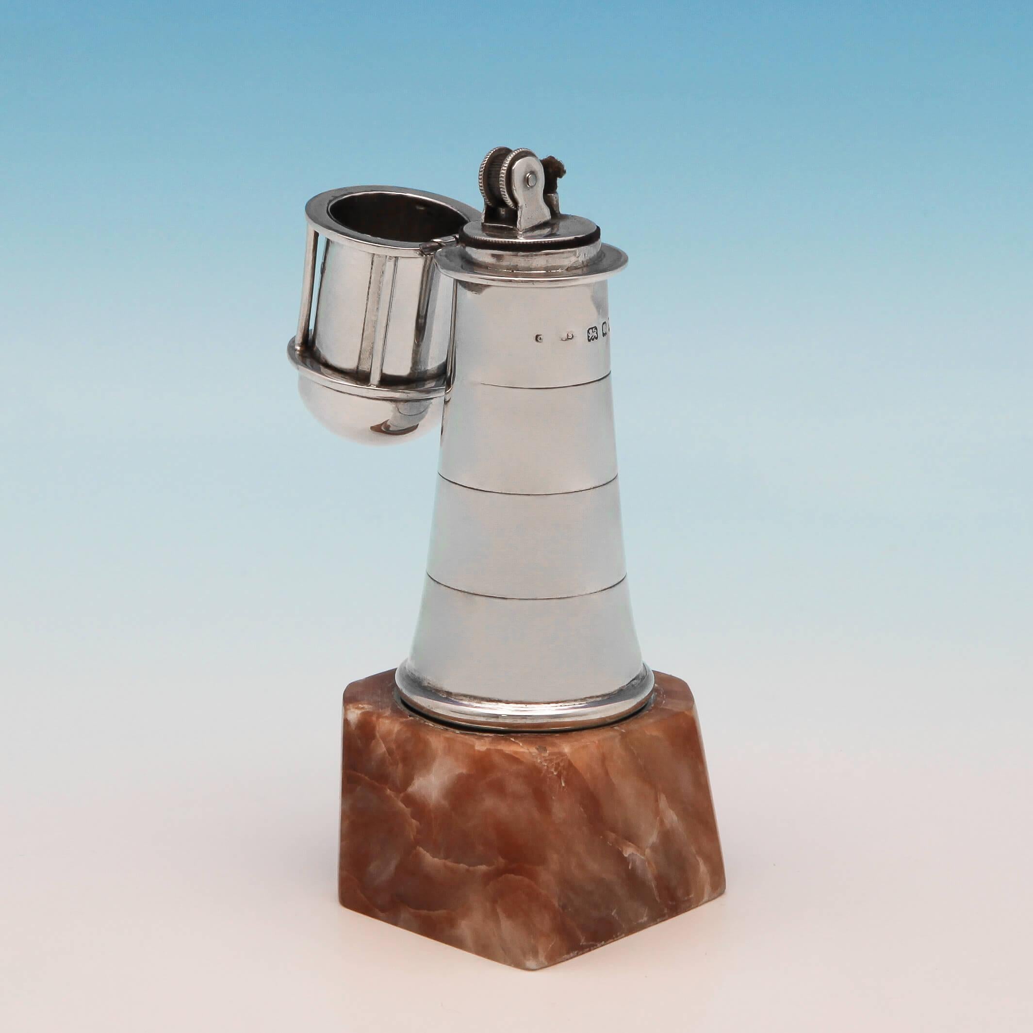 Hallmarked in London in 1932, this unusual, George V, sterling silver cigar lighter, is modelled in the shape of a lighthouse, standing on a soapstone base. The cigar or cigarette lighter measures: 5