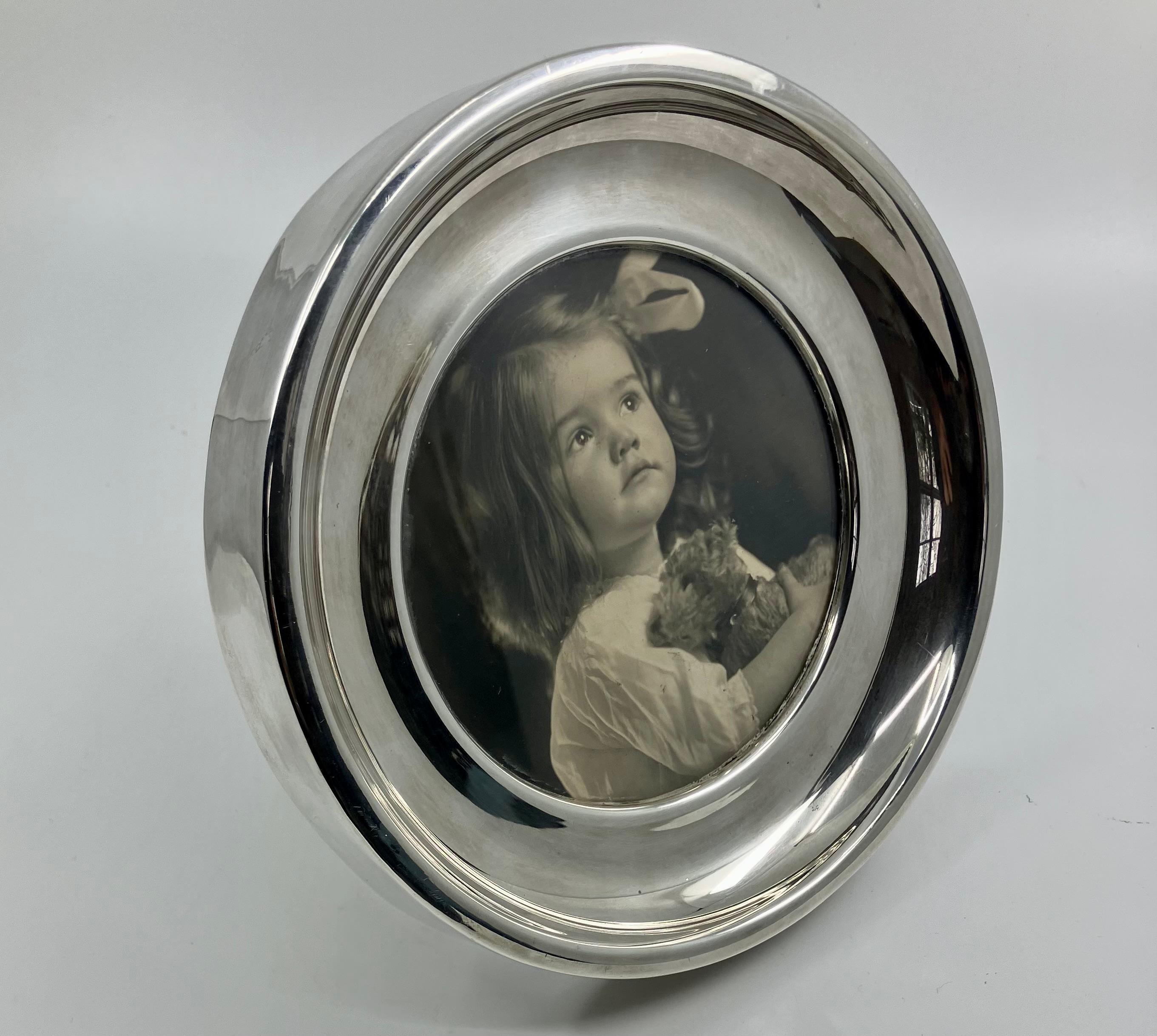 Sterling Silver Circular Standing Frame. Vintage Mexican sterling portrait frame with easel back.  Stamped “EMP•PLAT•MEX •S.A” STERLING 0.925 HECHO EN MEX. & ME 15. Mexico, 20th century. 

Dimensions: 7” dia x 1” deep; 4 3/8” diameter sight
