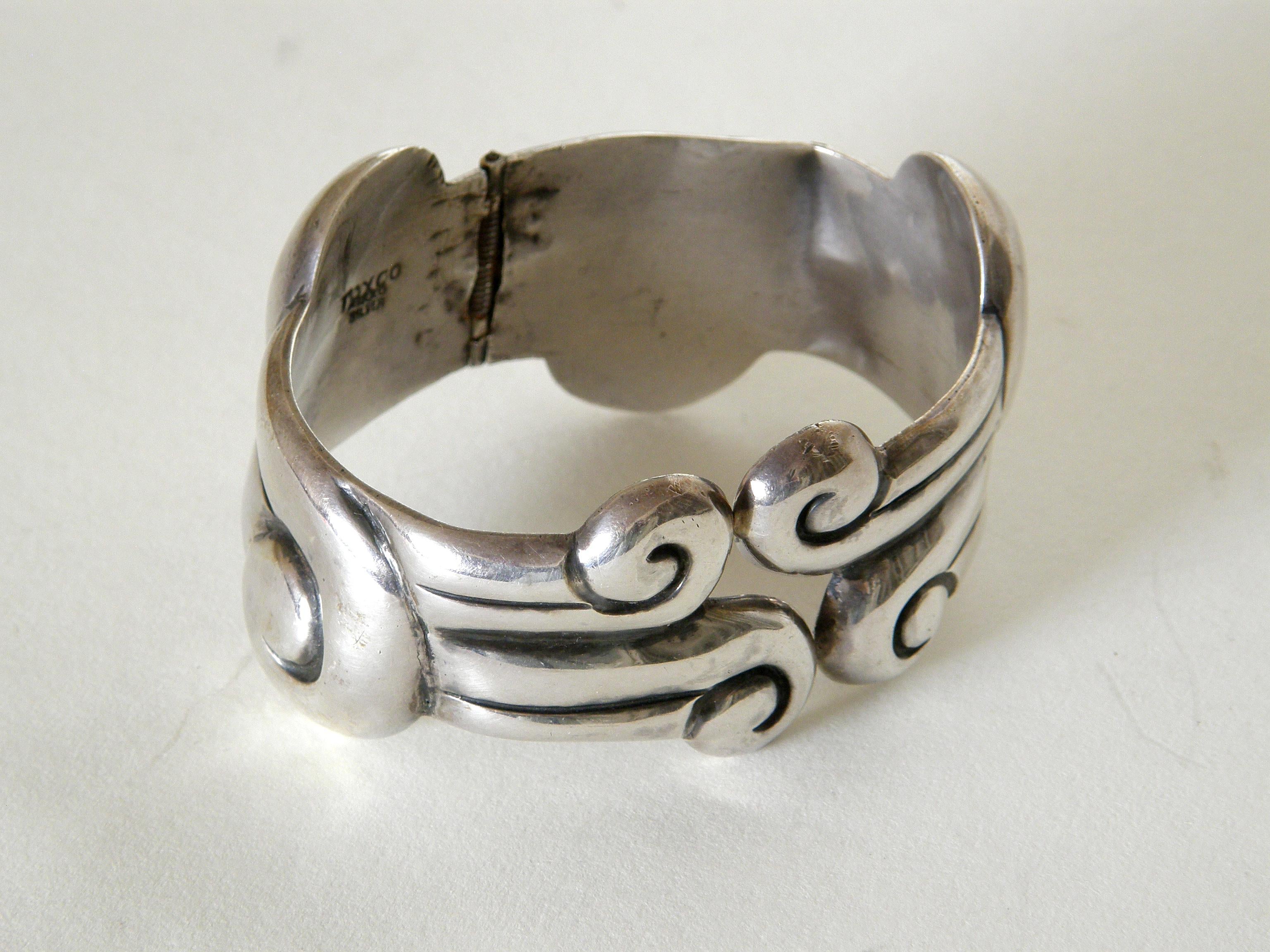 This sterling silver clamper bracelet was made in Taxco, Mexico. The scrolling design looks like stylized blowing wind or rolling waves. The spring is very strong and holds well.

marked : 