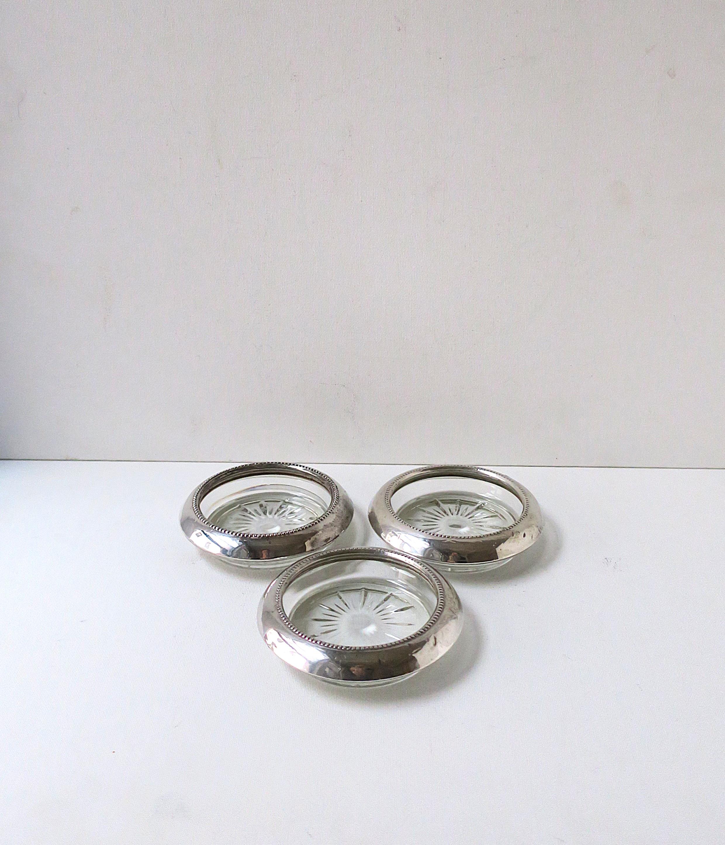 Ein Satz von drei (3) Cocktailuntersetzern aus Sterlingsilber und Glas, circa Anfang des 20. Jahrhunderts. Untersetzer aus Sterlingsilber mit kleinen Perlendetails, auf einem Glassockel mit Starburst-Design. Unverzichtbar für den Schutz von