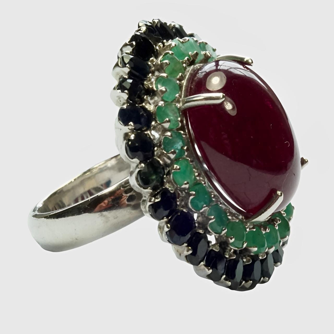 Fabulous sterling silver ring, featuring a centre ruby surrounded with blue sapphire and emerald gemstones.

Ring size UK N, US 6 1/2, inside diameter 1.8 cm / .7 inch, and measuring length 3.3 cm / 1.29 inches by 2.9 cm / 1.1 inches. The ring is in