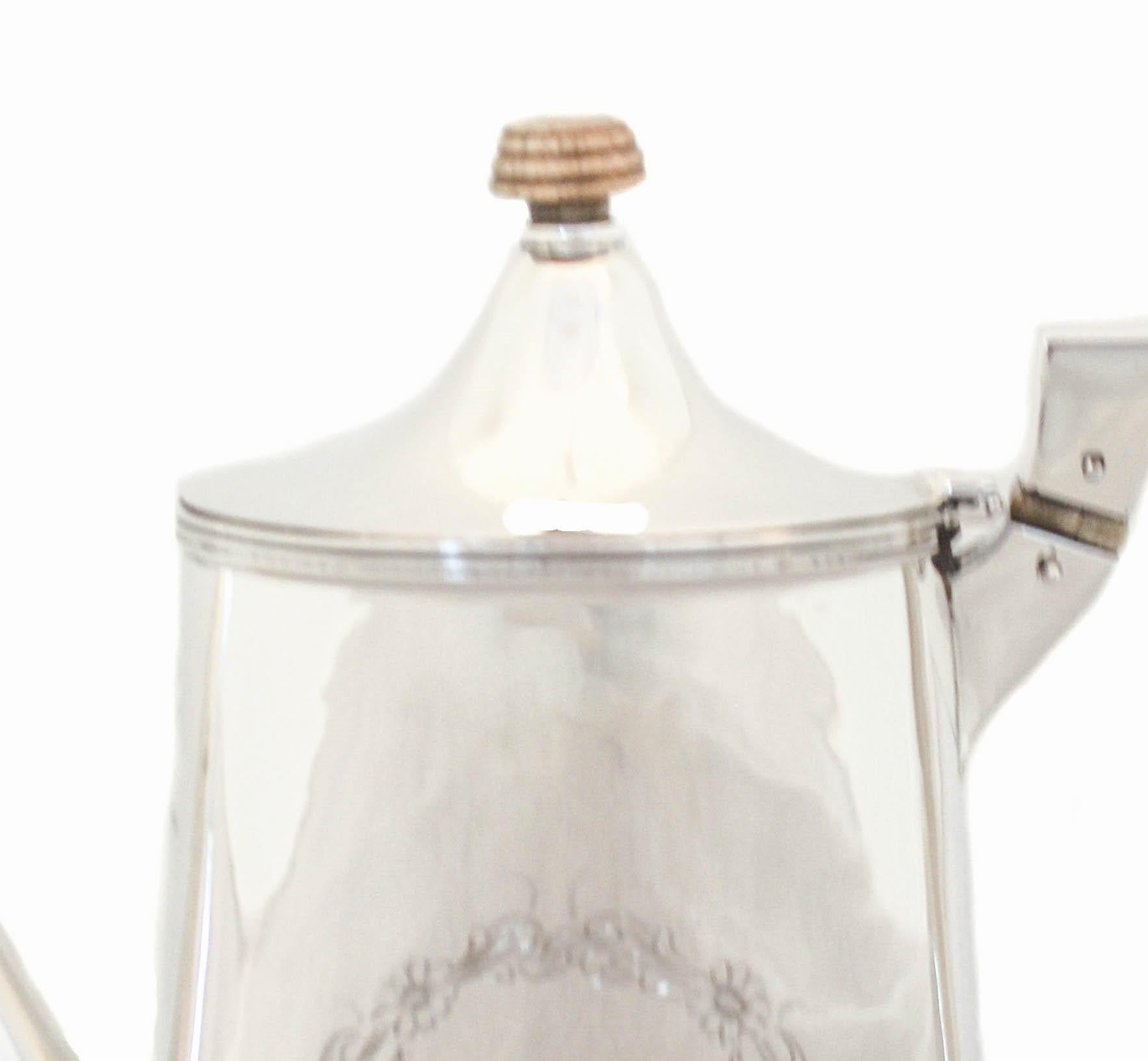 I’m delighted to offer you this sterling silver coffee/tea pot by Richard Dimes Silver of Boston, Massachusetts. Designed in the federalist style it is austere and simple. There is a floral motif on each side but nothing else. On one side there is a
