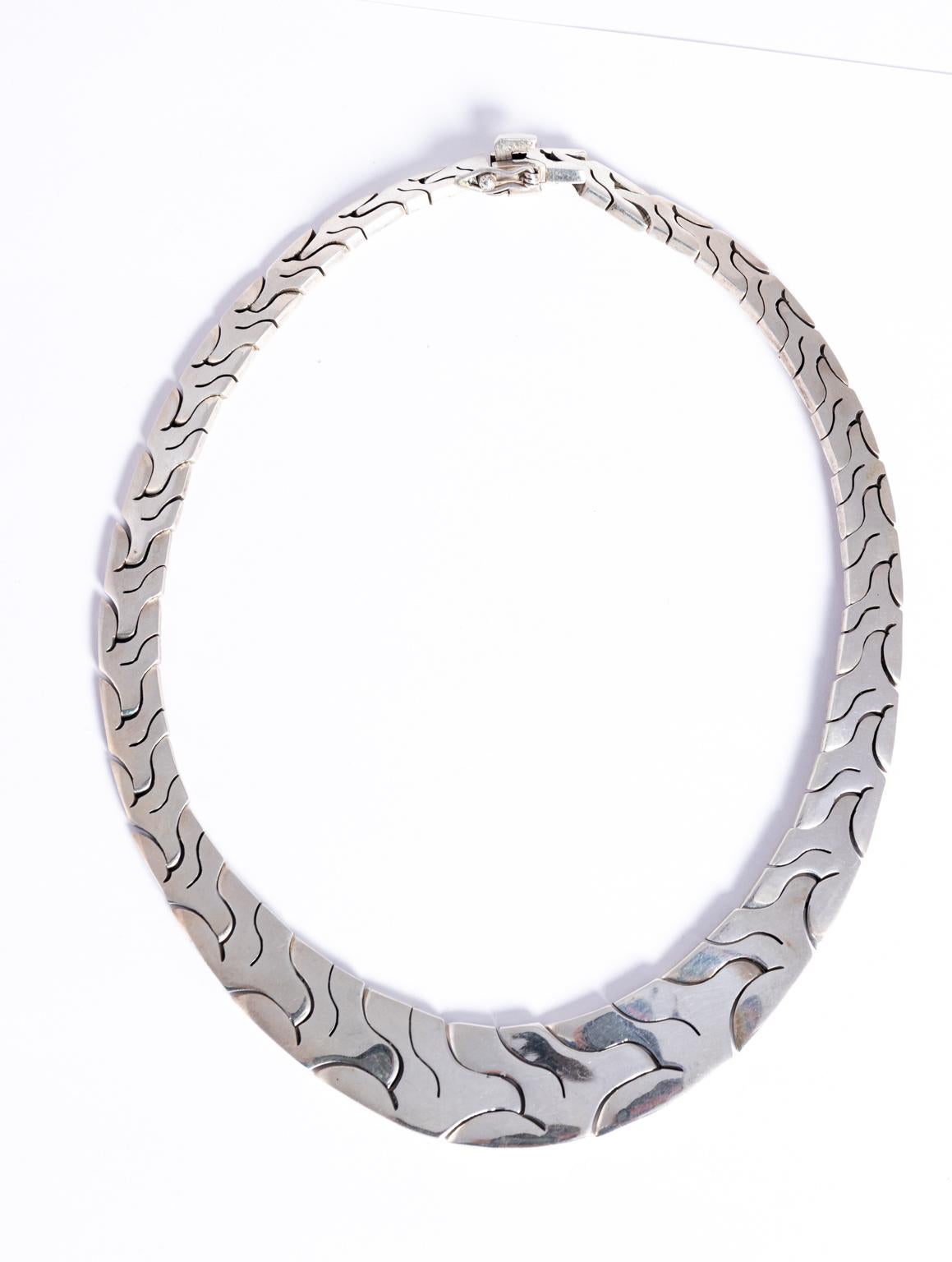 Circa 1970s handmade Sterling silver collar necklace, signed. The piece features abstract interconnecting links following a circular design from smaller in the back to larger in the center. Made in Mexico. The outside width measures 19.25 Inches,
