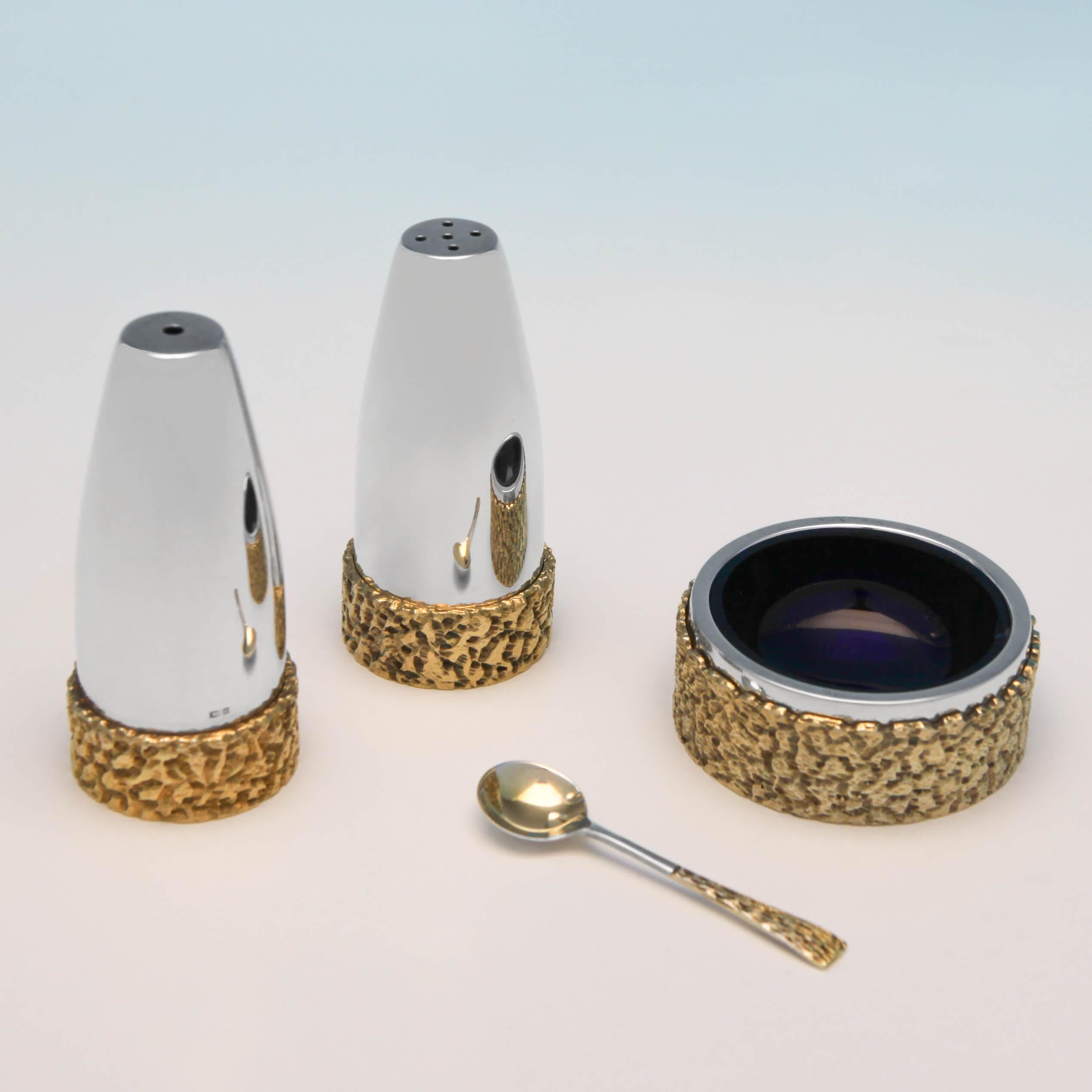 Hallmarked in Birmingham in 1973 by Deakin & Francis, this handsome, Elizabeth II, sterling silver condiment set, is simple in shape, and has been decorated with a gilt bark effect around the bases. The mustard pot measures 2.25