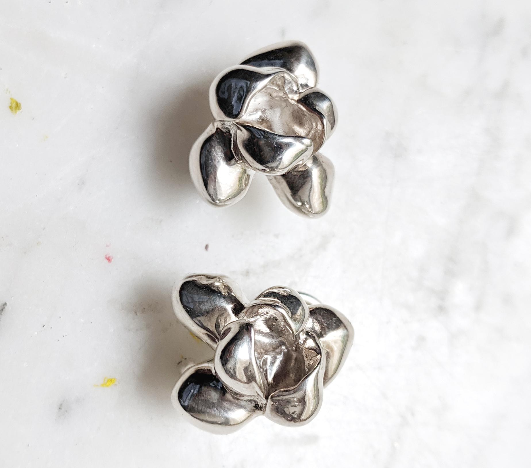 These Iris Blossom stud earrings, designed by artist Polya Medvedeva from Berlin, are crafted from sterling silver. The sculptural design of the earrings provides an extra shiny surface to the flowers, creating a subtle play of shadow and light.